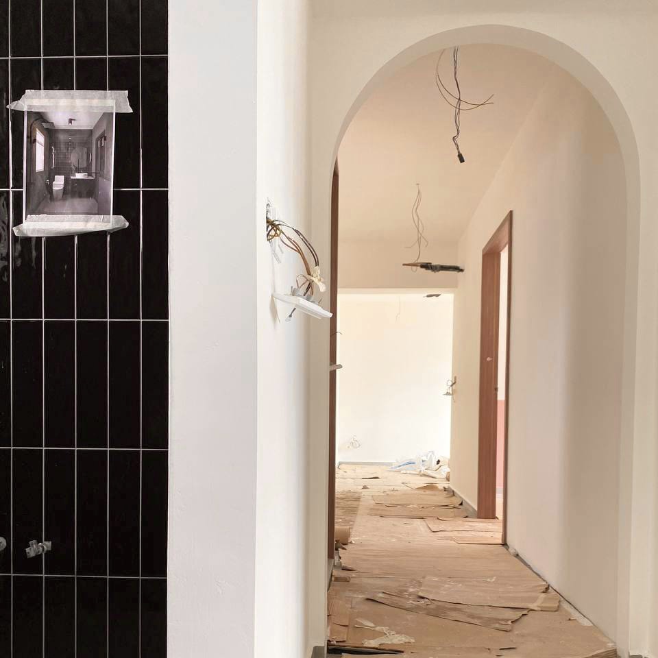 Why we will definitely get an ID for renovation!  - Black tiled bathroom interior, white archway, exposed wiring, unfinished