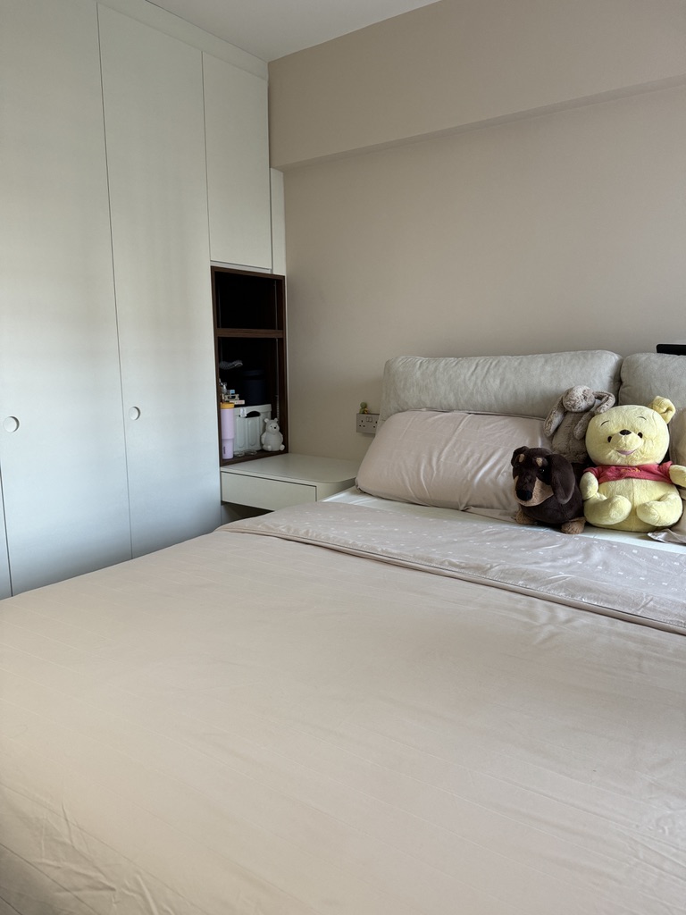 Why We Chose to Invest in an ID - White bedroom with minimalist design, beige bedding, plush toys on bed, built-in wardrobe