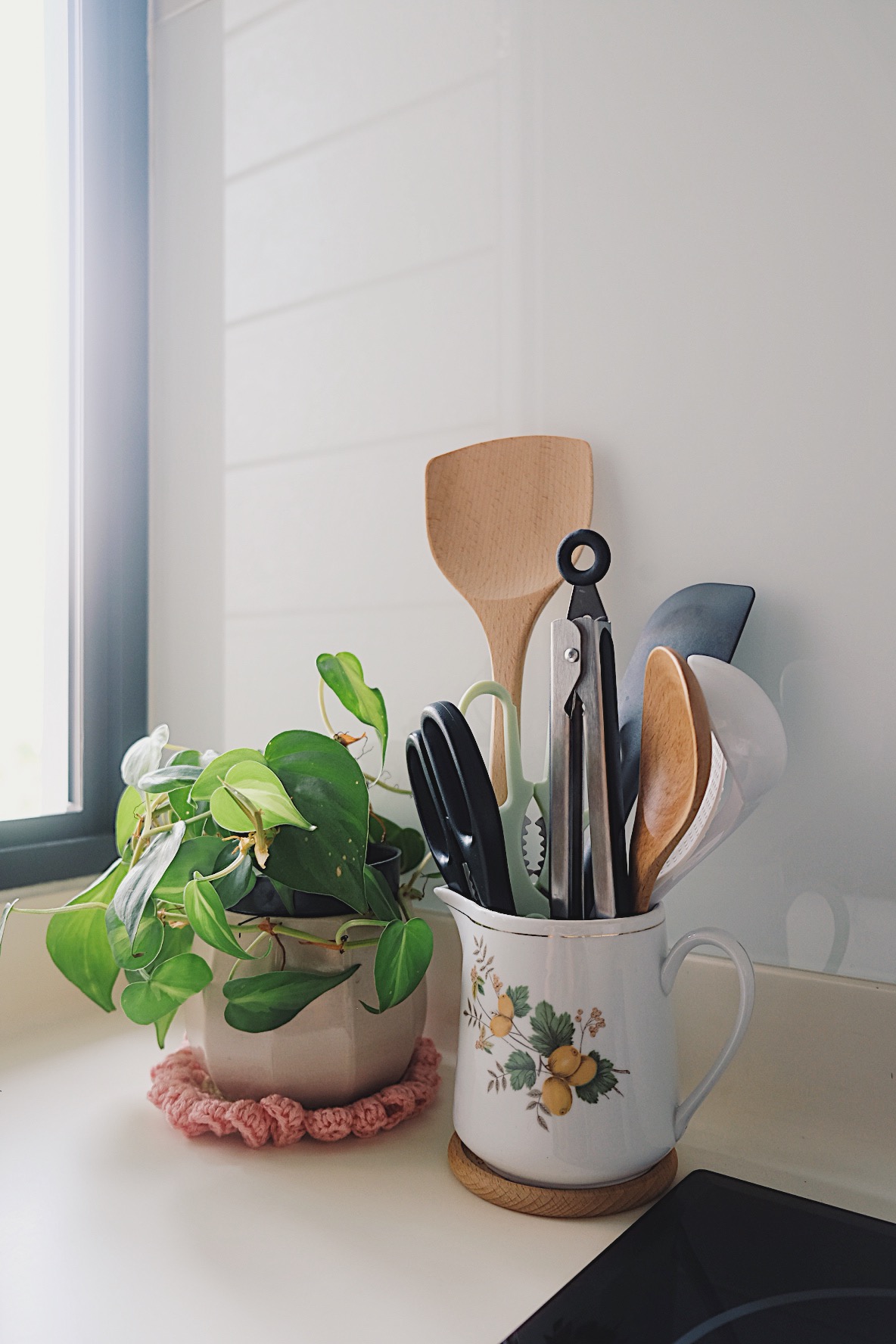 How we make a tiny condo kitchen functional and aesthetic - vibrant green potted plant, natural light streaming in, wooden