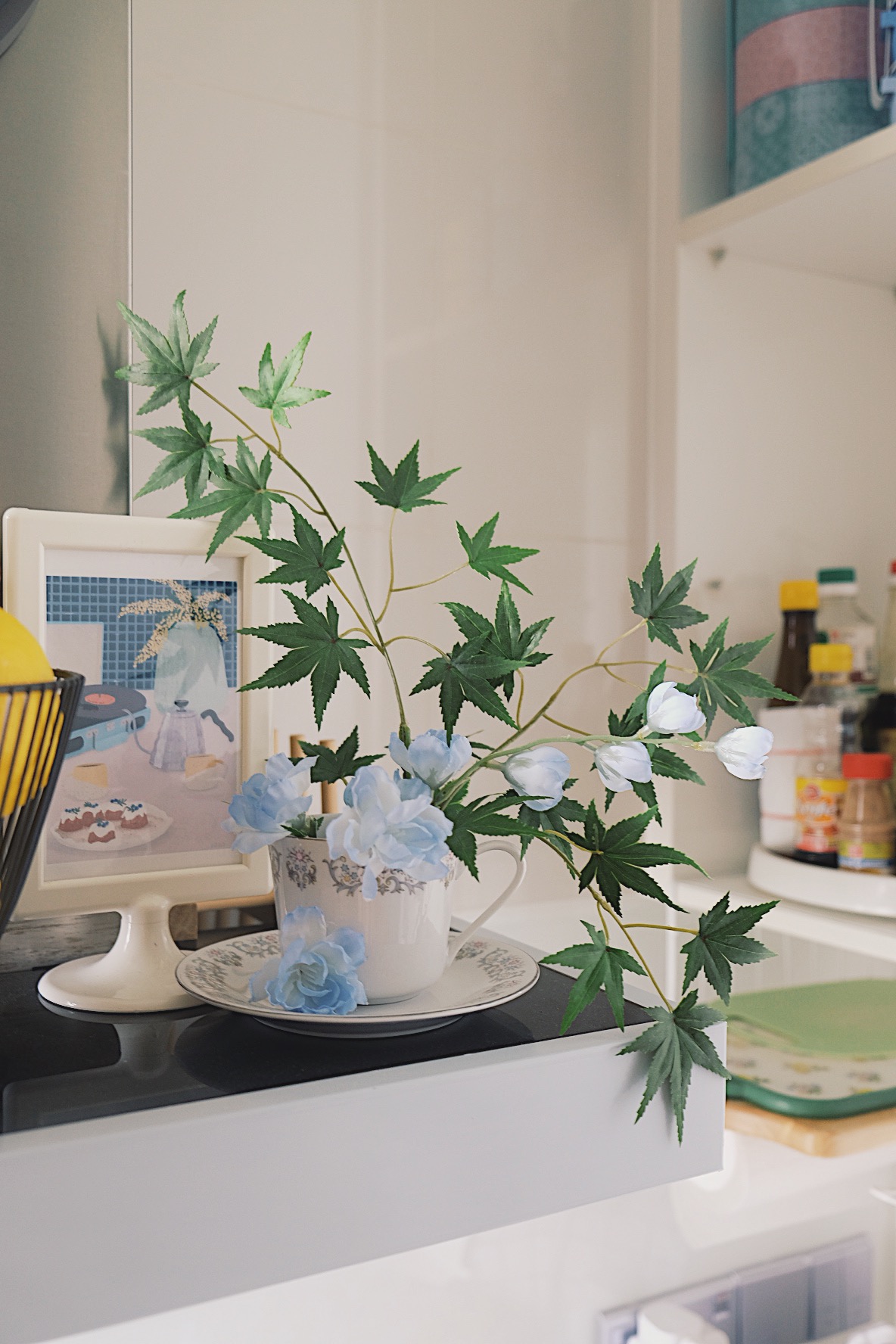 How we make a tiny condo kitchen functional and aesthetic - vibrant green leaves, delicate blue flowers, abstract painting