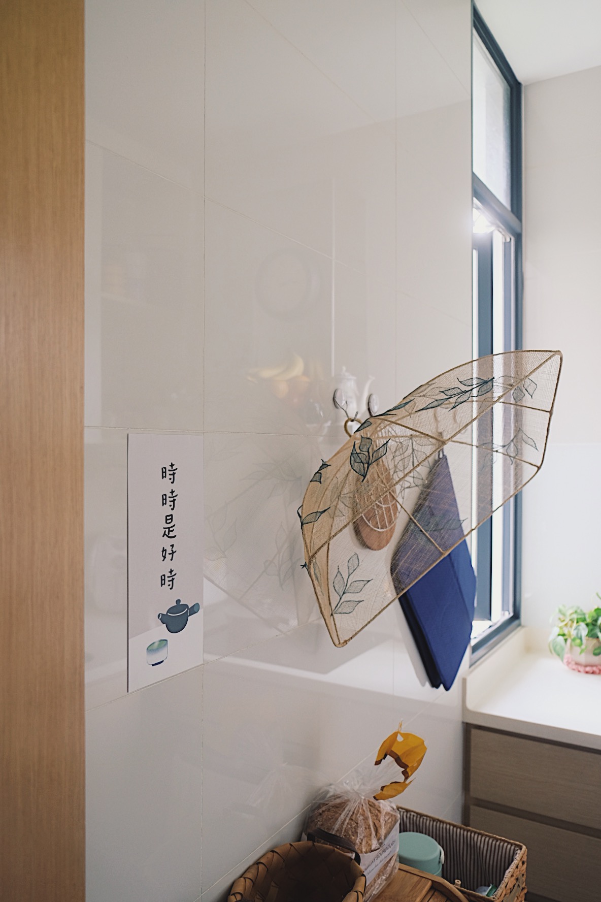 How we make a tiny condo kitchen functional and aesthetic - White tiled wall, hanging umbrella, blue towel, wooden basket