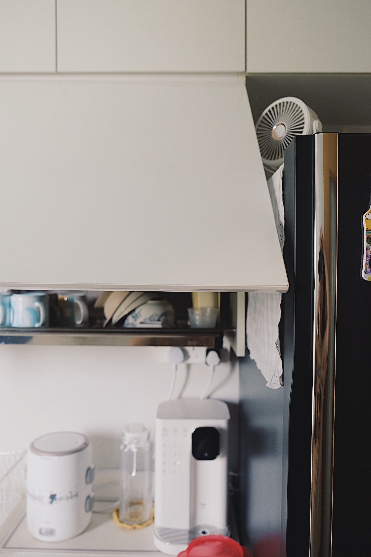 How we make a tiny condo kitchen functional and aesthetic - White kitchen countertop, modern appliances, white cup shelf