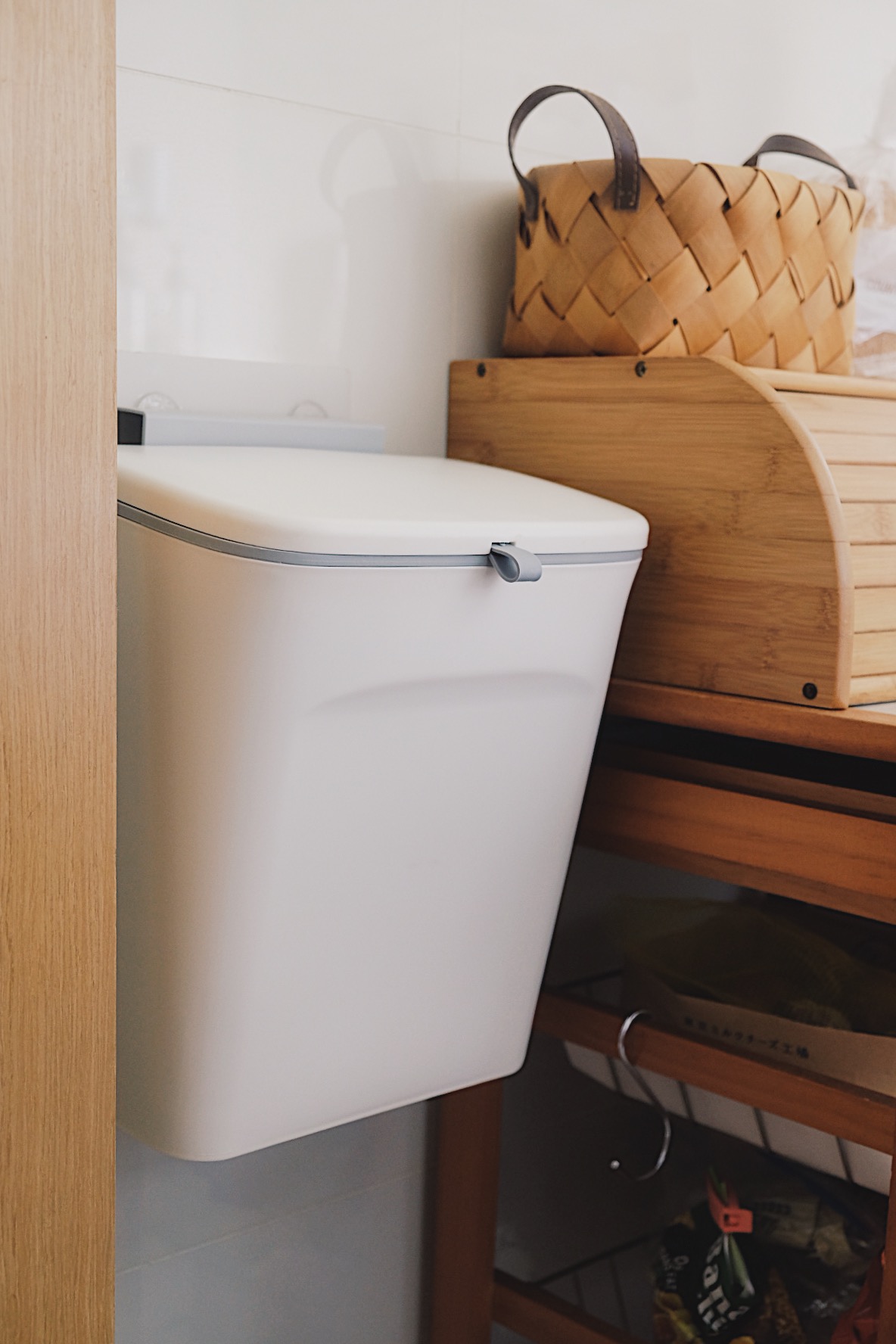 How we make a tiny condo kitchen functional and aesthetic - White toilet with gray handle, wooden shelf, woven basket, wooden
