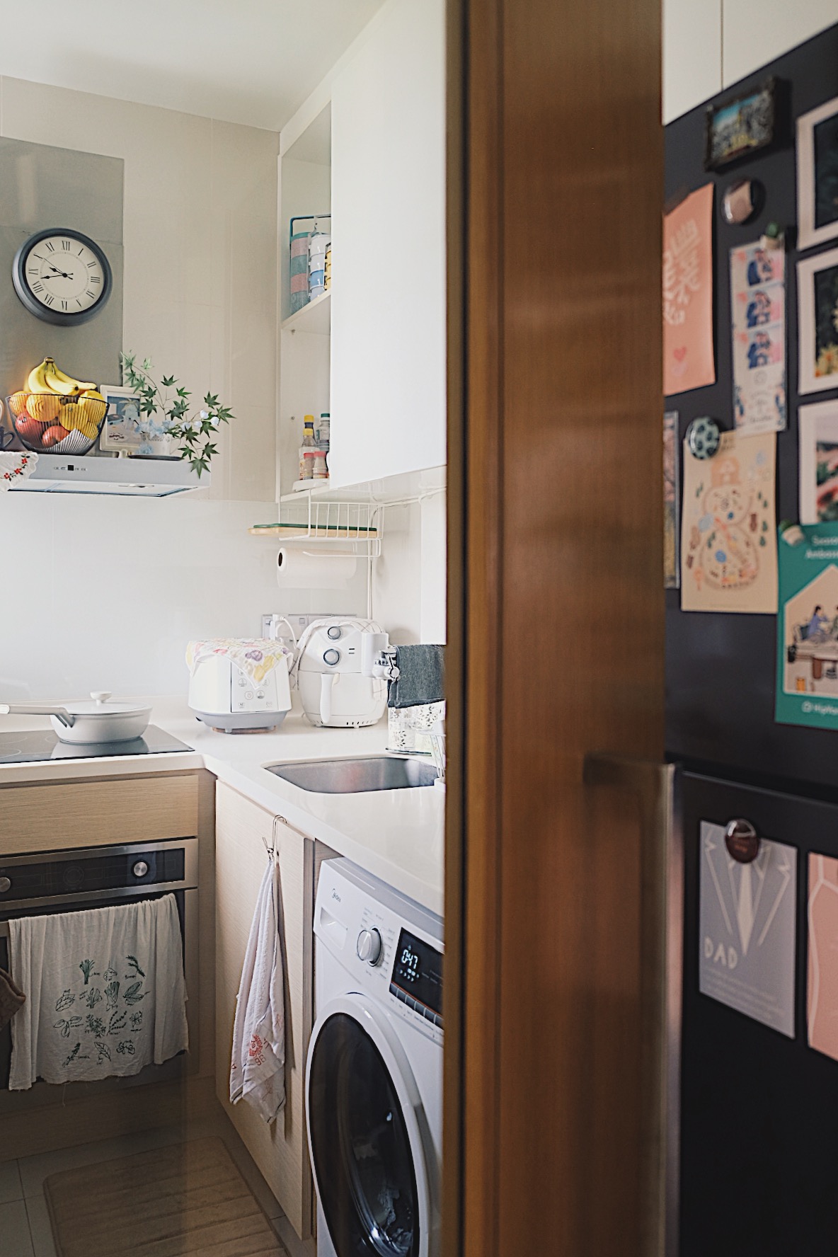 How we make a tiny condo kitchen functional and aesthetic - Kitchen with modern appliances, white cabinets, wooden door