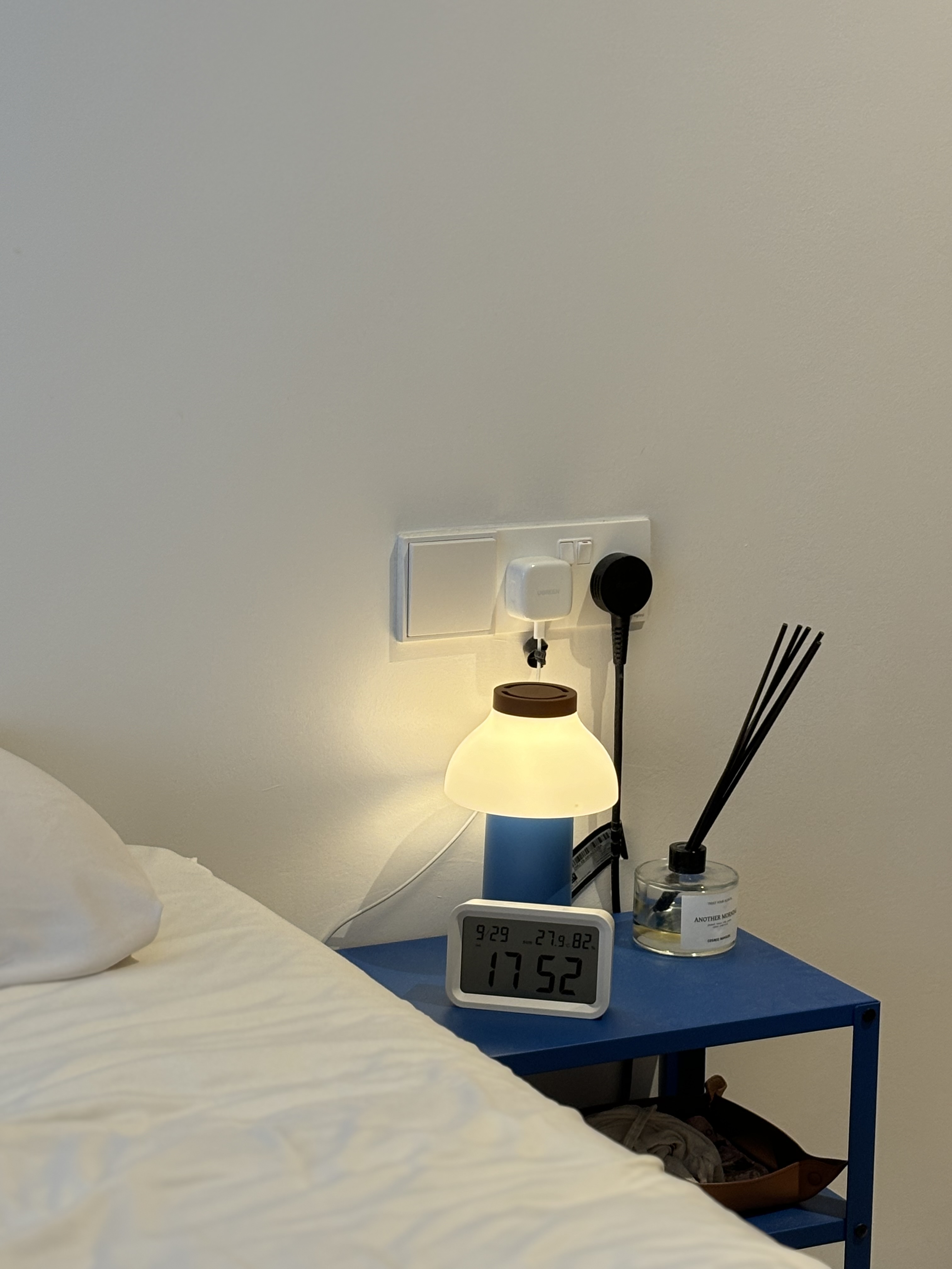 A Simple Mid-Century Modern 4-Rm BTO under $60k - Digital clock displaying 9:29, white pillow, blue nightstand, white wall