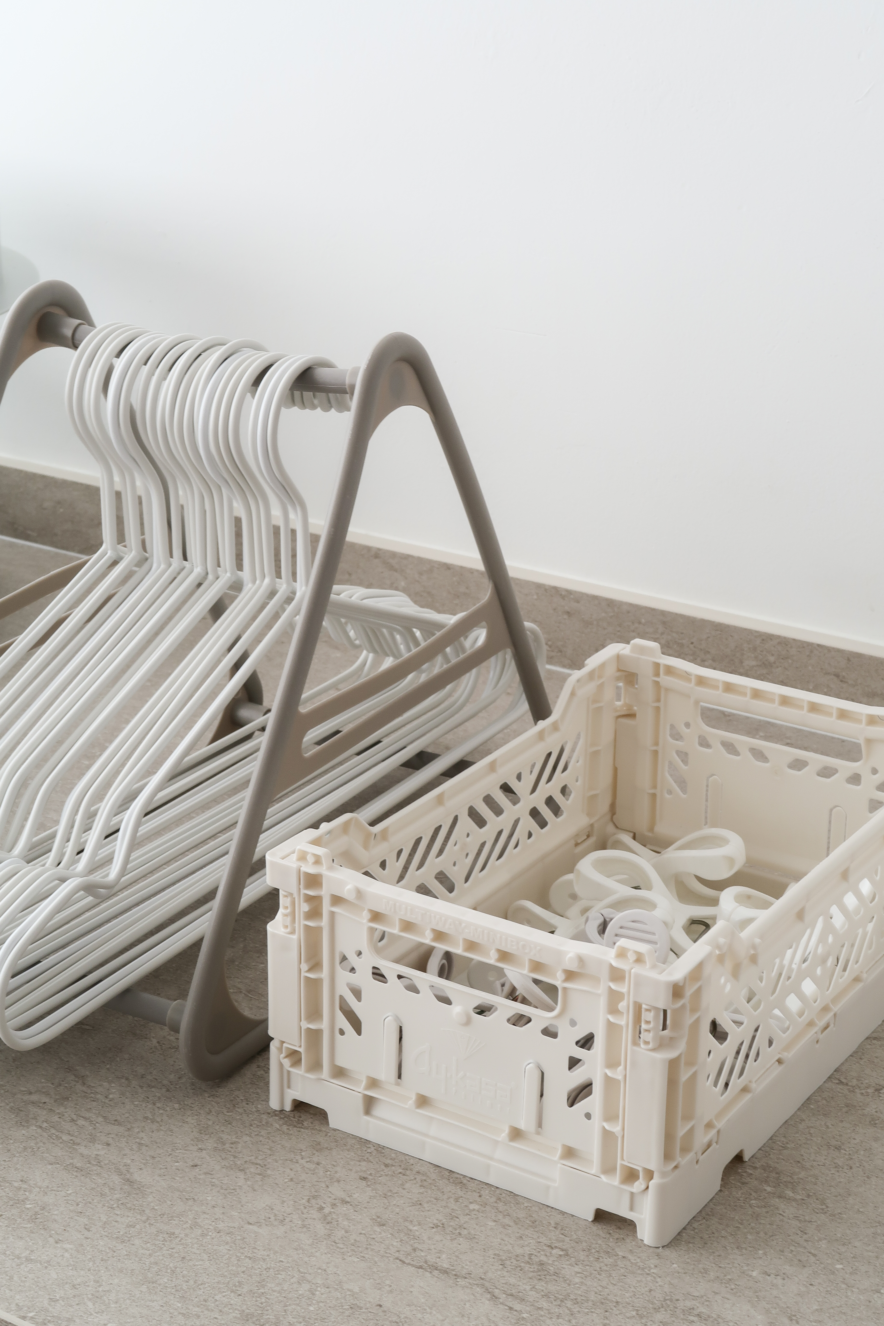 Service Yard: Making the Most of Small Spaces - White hangers, beige rack, plastic basket, countertop, light-colored floor