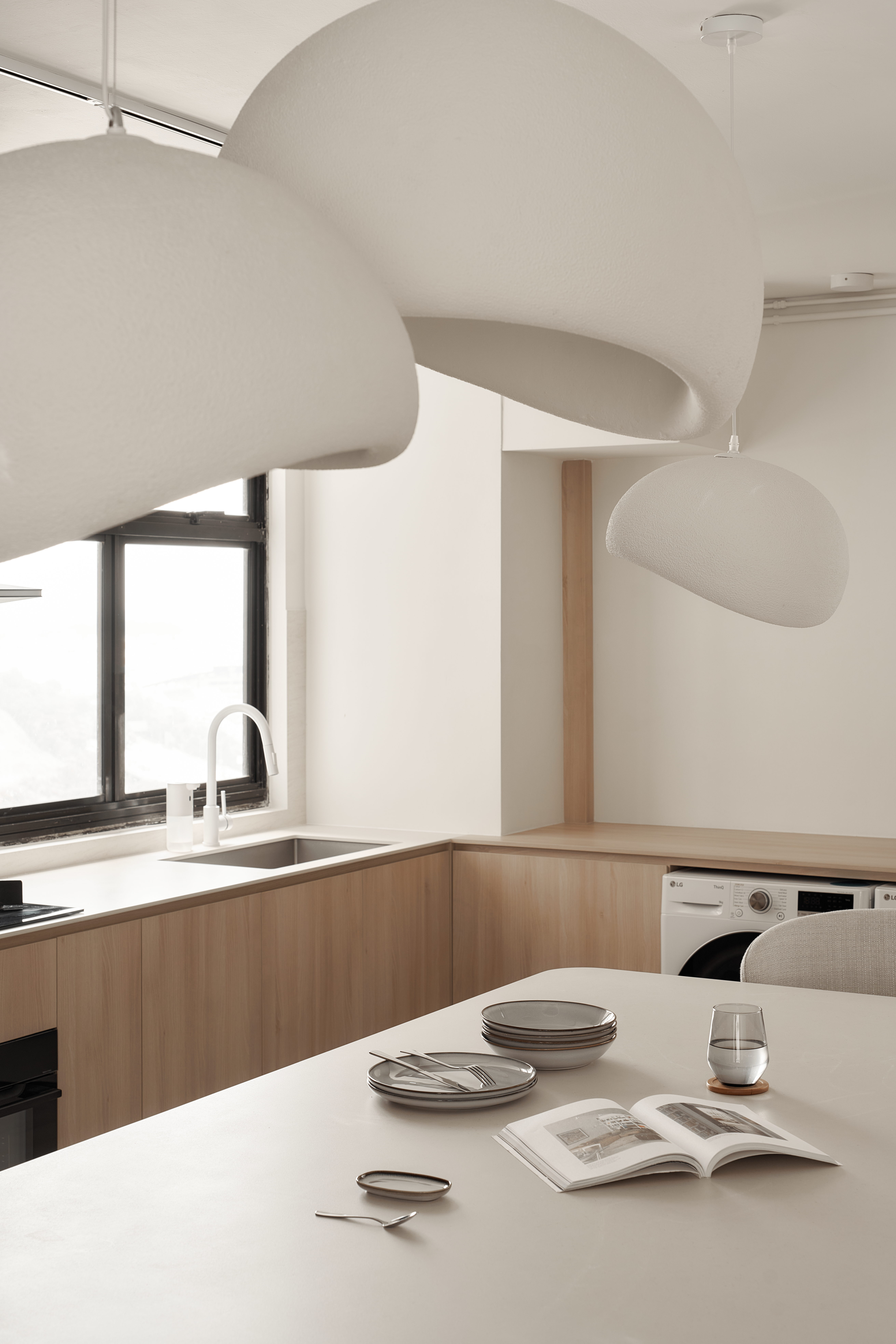 A Scandinavian-Inspired Haven of Modern Elegance - Modern kitchen with minimalist design, large pendant lights, sleek sink