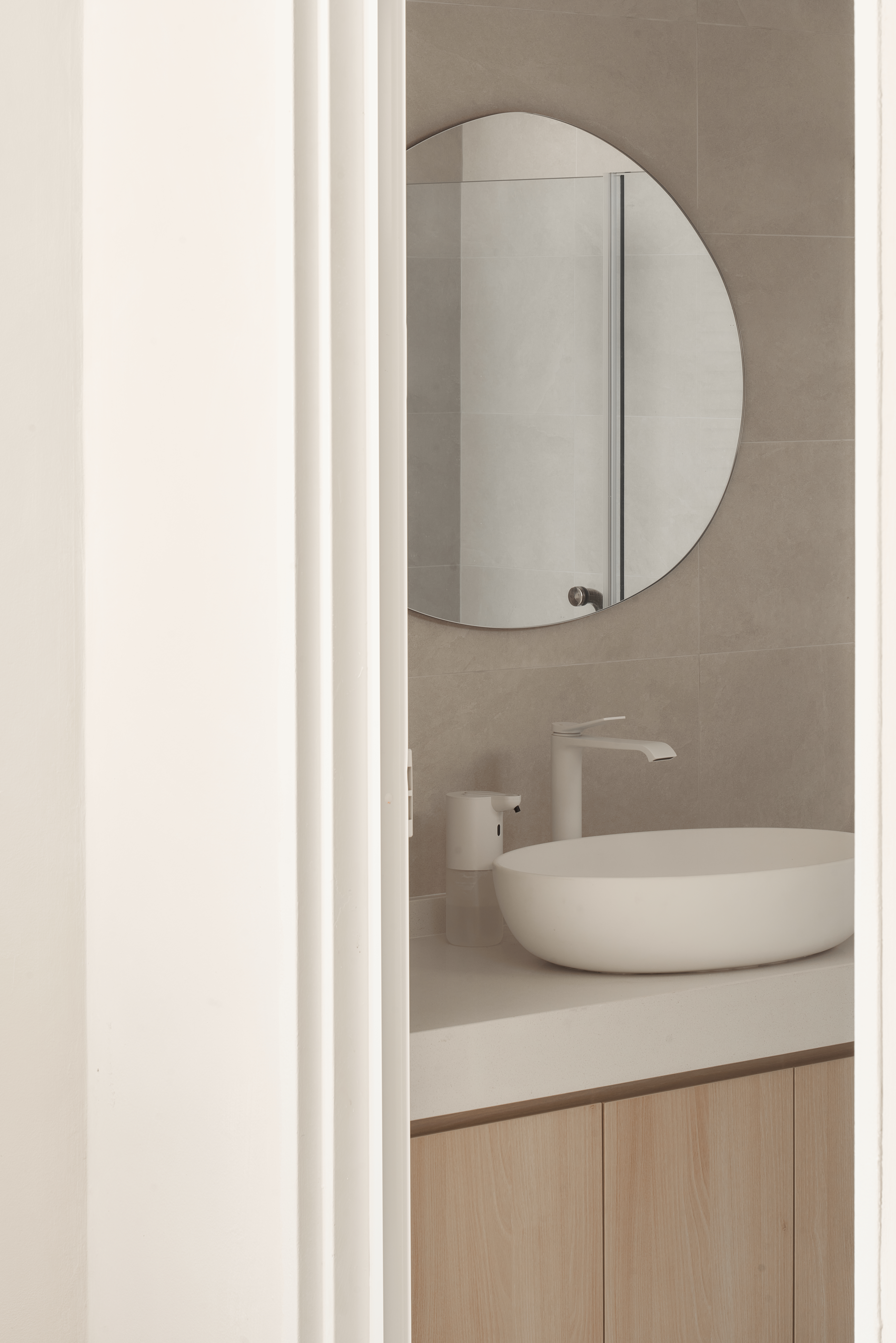 A Scandinavian-Inspired Haven of Modern Elegance - Modern bathroom, minimalist design, round mirror, white sink, sleek