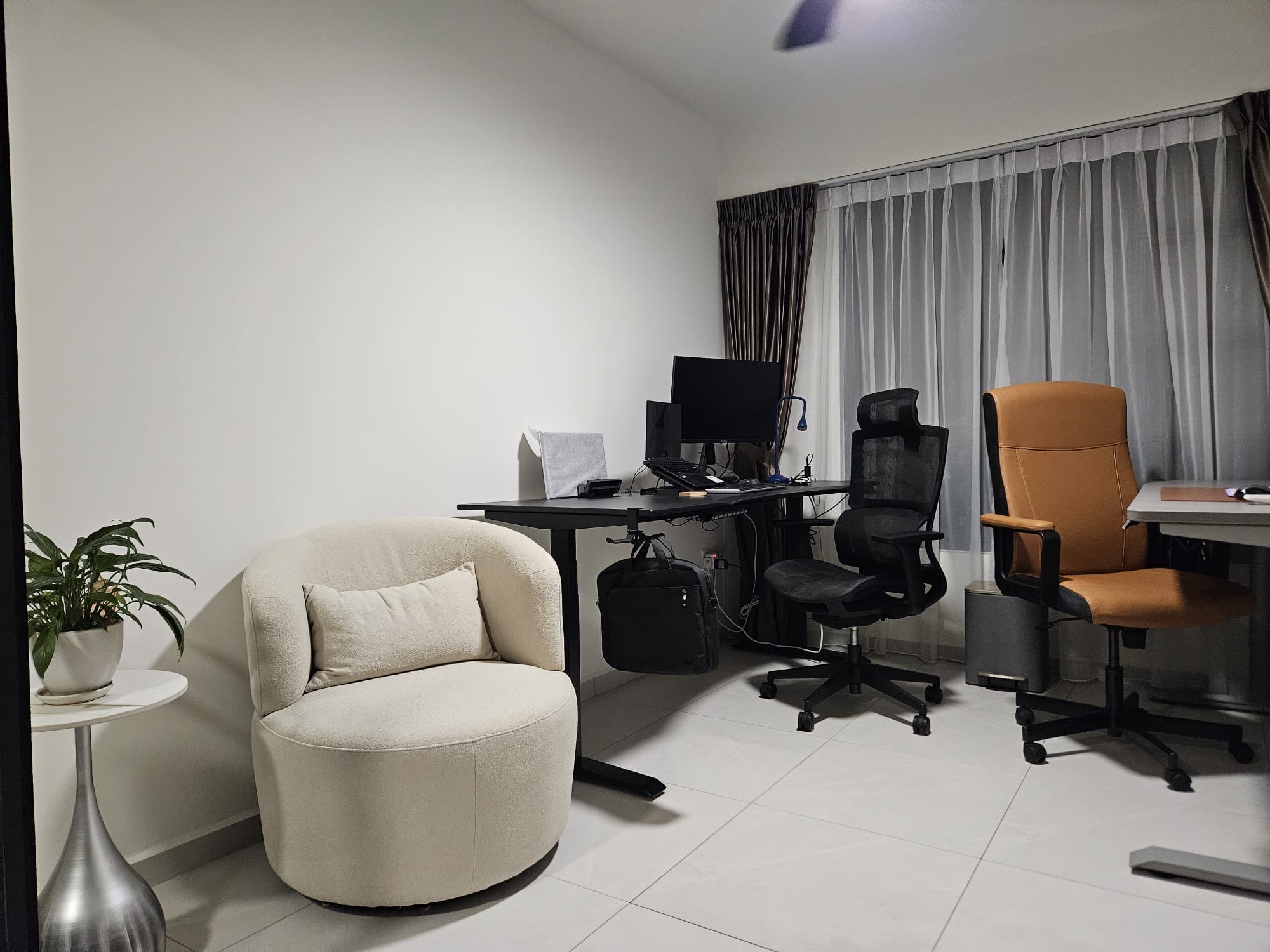 Comfy Corner - Modern minimalist home office, sleek black desk, ergonomic office chair, beige plush armchair, white tiled
