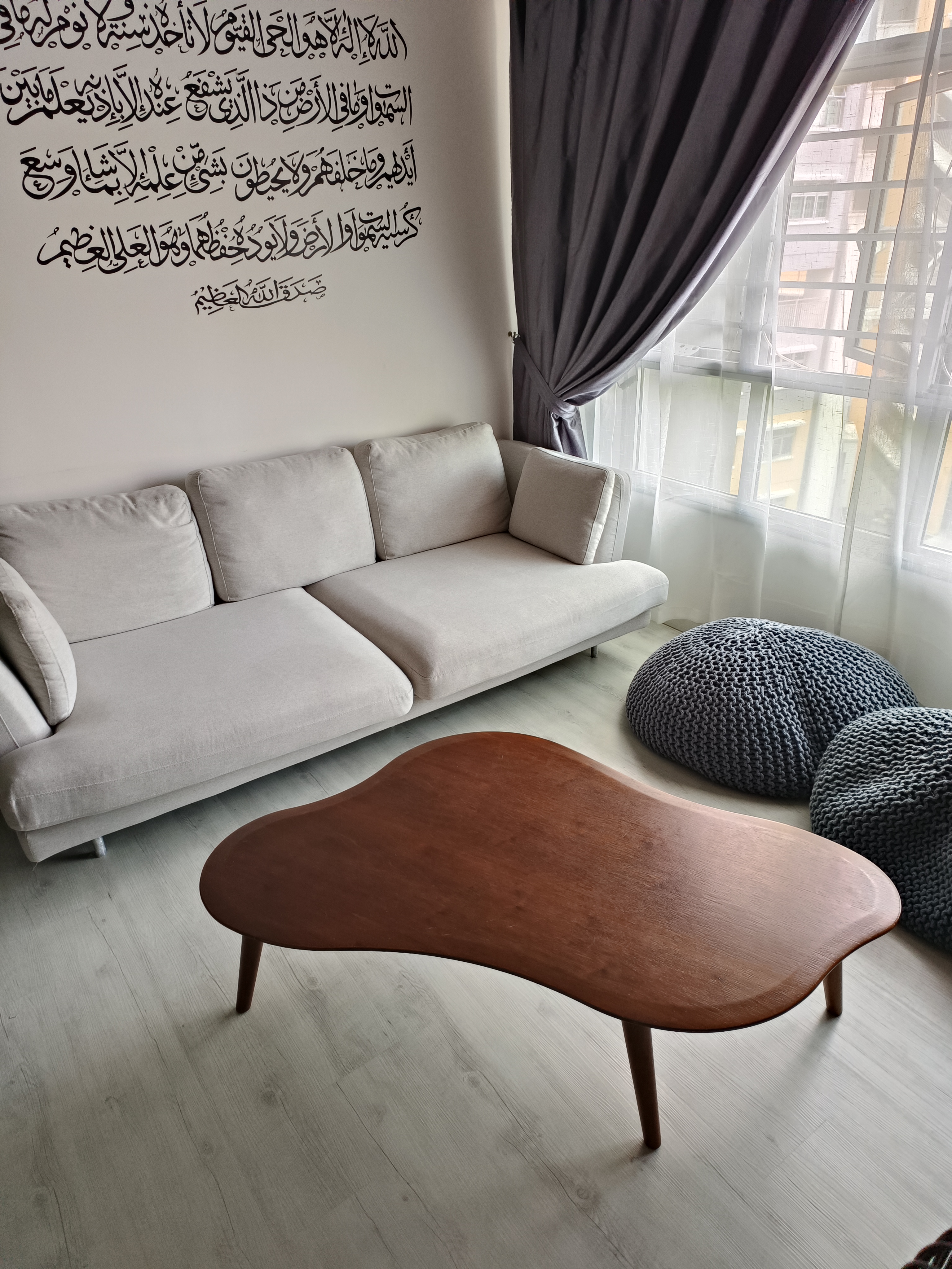 Sanctuary Space - Light gray sofa, modern design, beige cushions, wooden coffee table, light wooden floor, sheer curtains