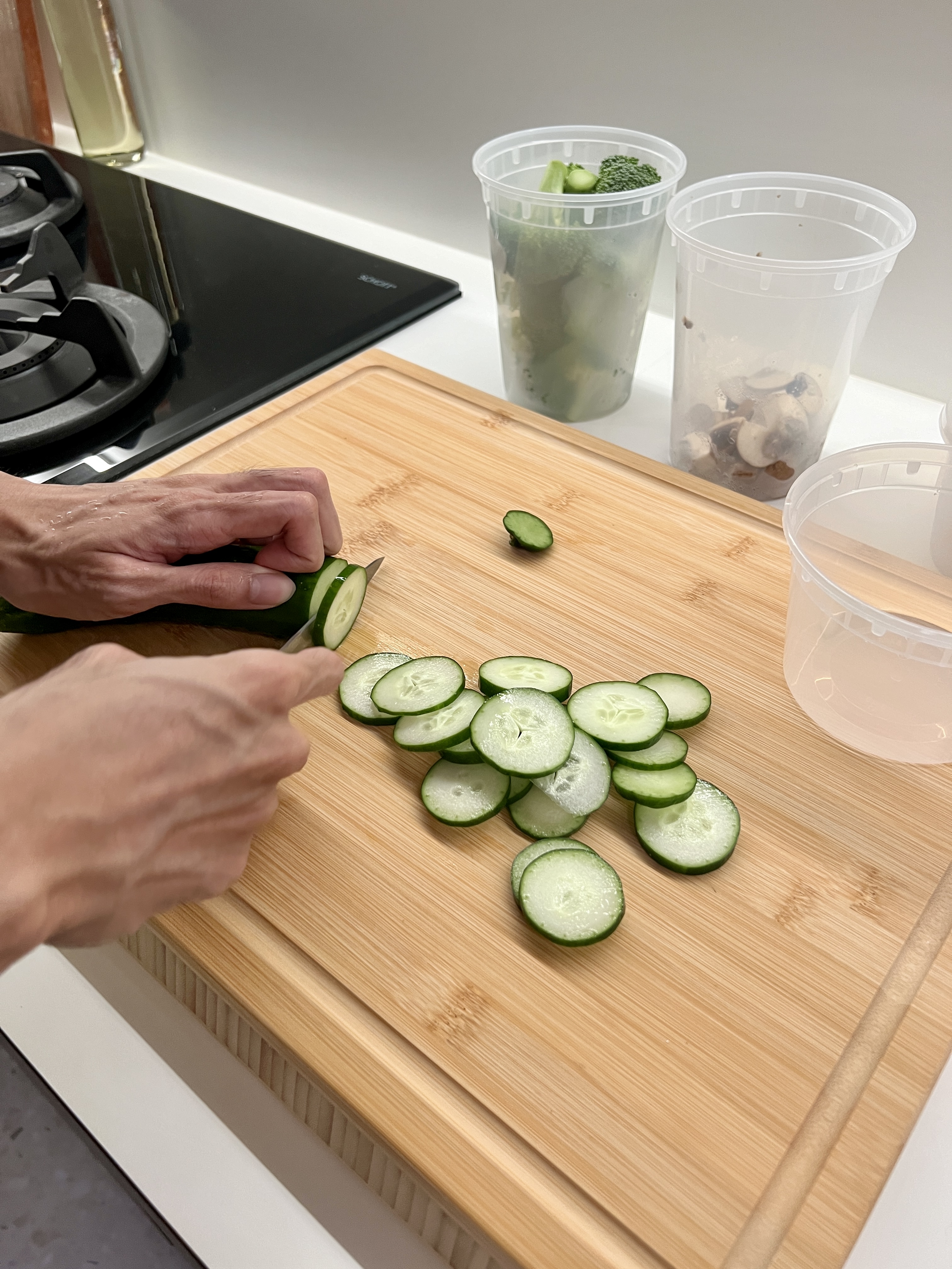 Optimising the kitchen experience for 2 monkeys 🙉🙊 - cutting cucumber on wooden cutting board, slicing cucumber, preparing