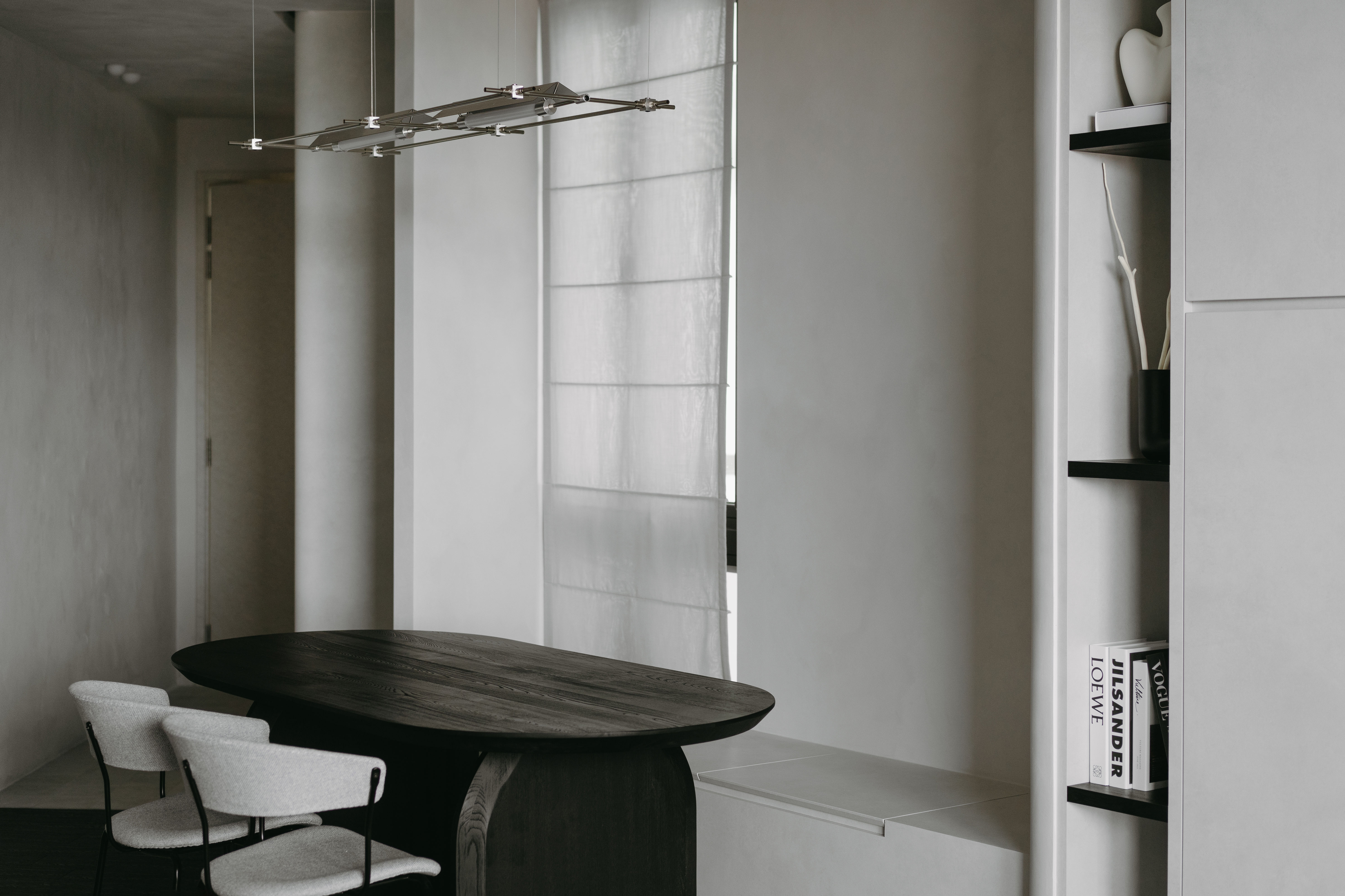 Welcome to our Grey Oasis—Minimalist vibes with sneaky storage! - modern minimalist dining room, sleek black table, white