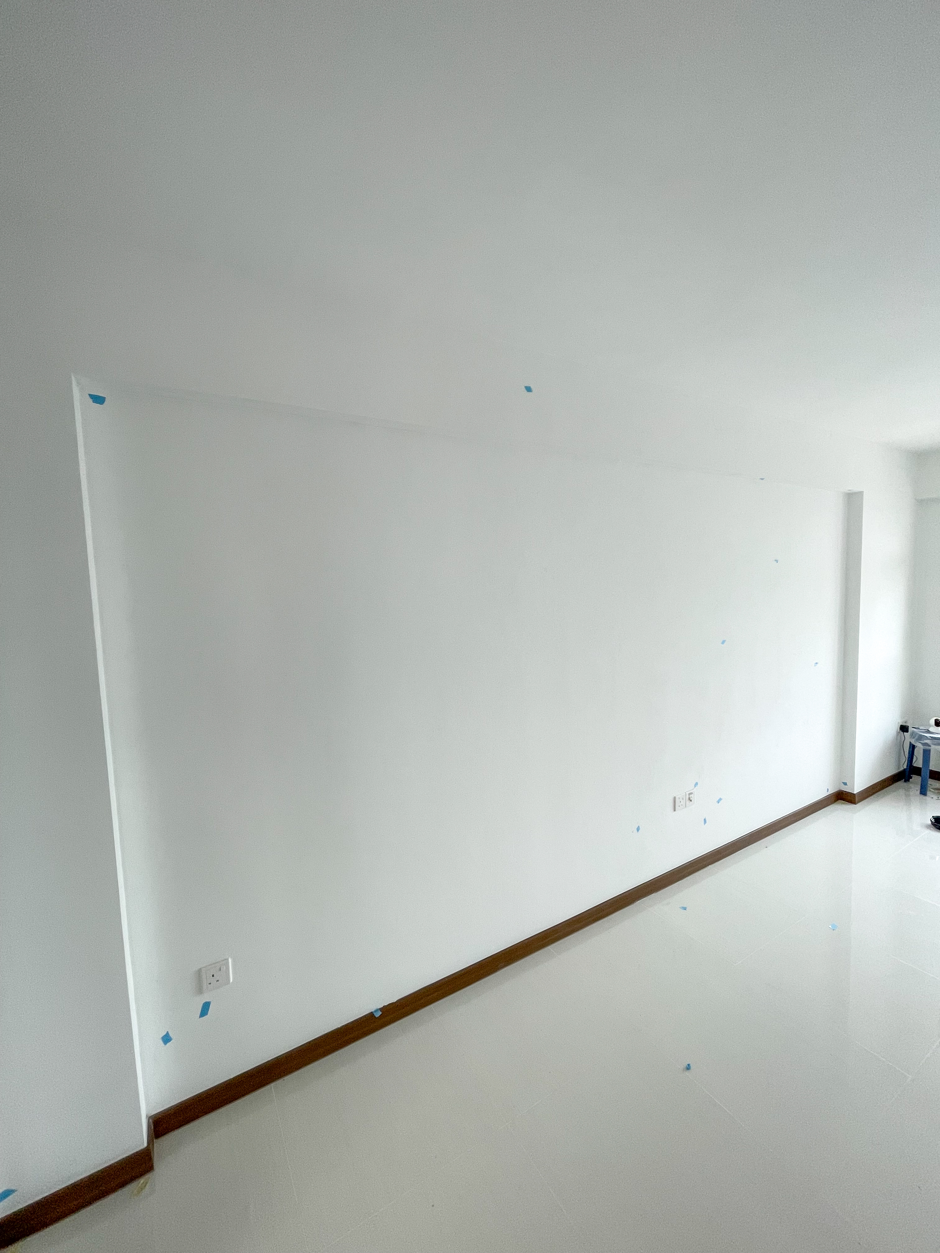 Our Entryway: The Transformation of Our 4-Room BTO - White walls, bare concrete, blue tape, glossy floor, minimalistic