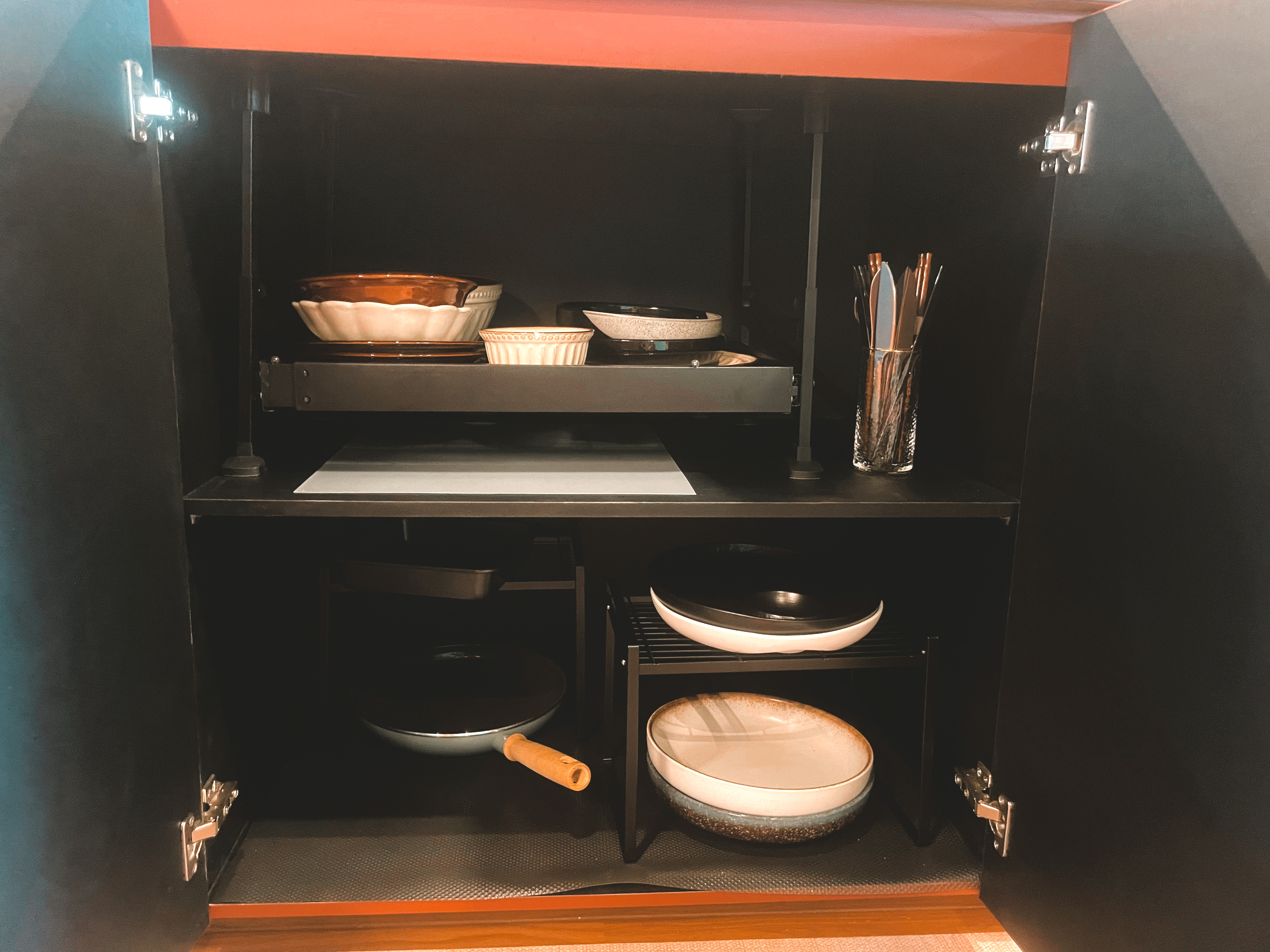 Kitchen Organization: The Ongoing Journey - Shelf with various kitchen utensils, including bowls, a spatula, and a frying