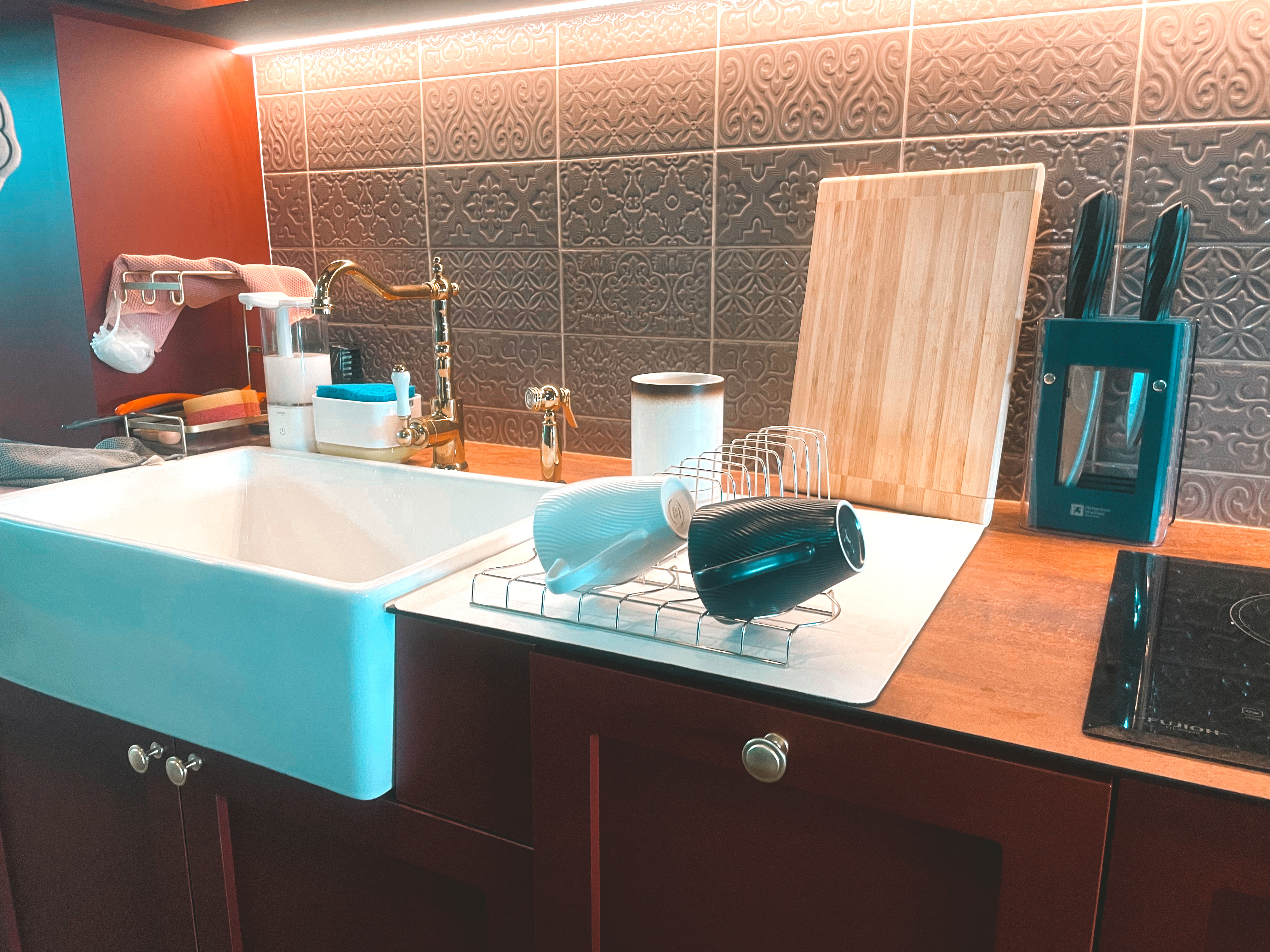 Kitchen Organization: The Ongoing Journey - Modern kitchen sink, blue countertop, stainless steel faucet, wooden cutting