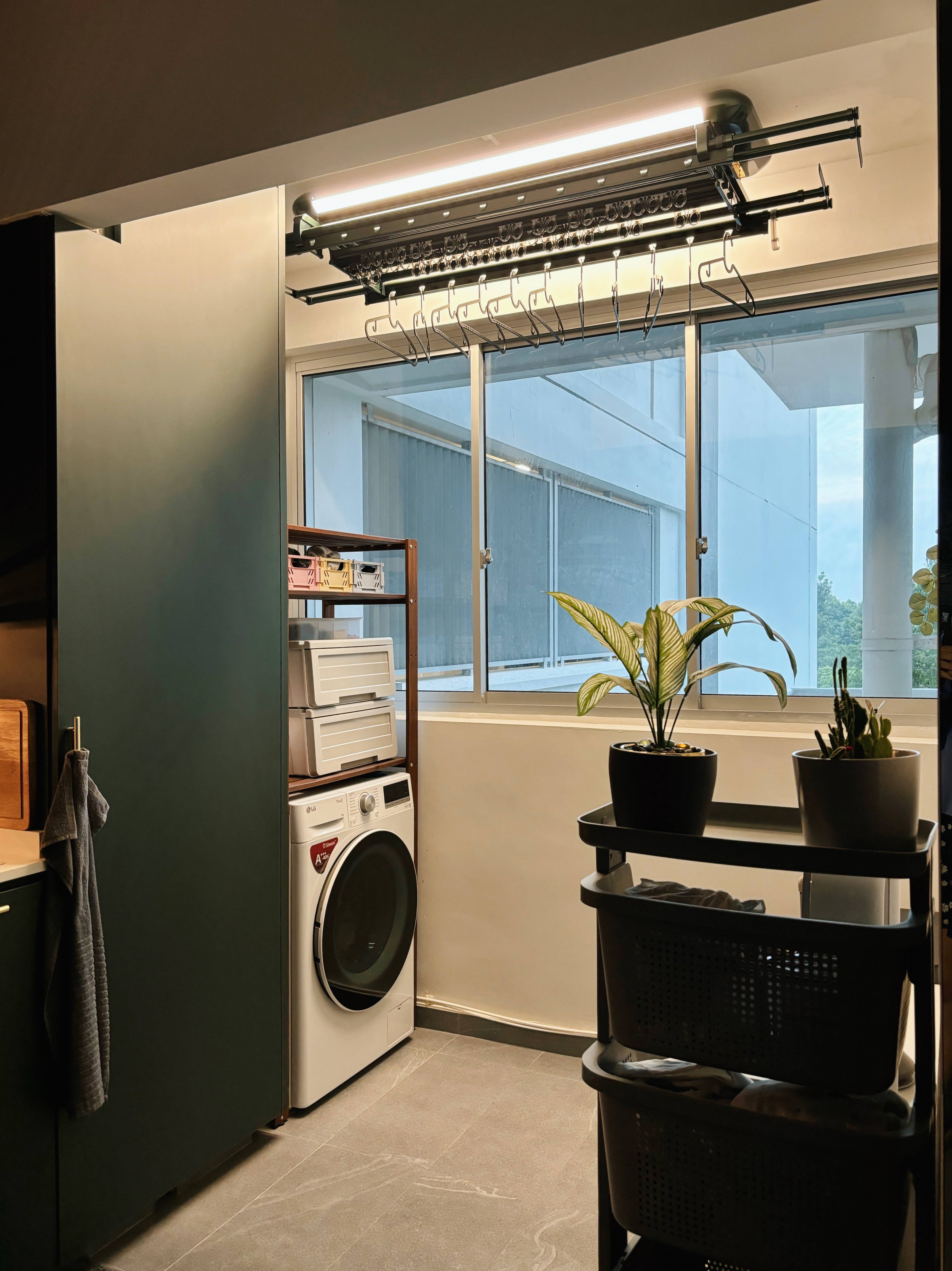 How We Made Our Service Space Work for Us - Modern laundry room, hanging hangers, white washing machine, green plants
