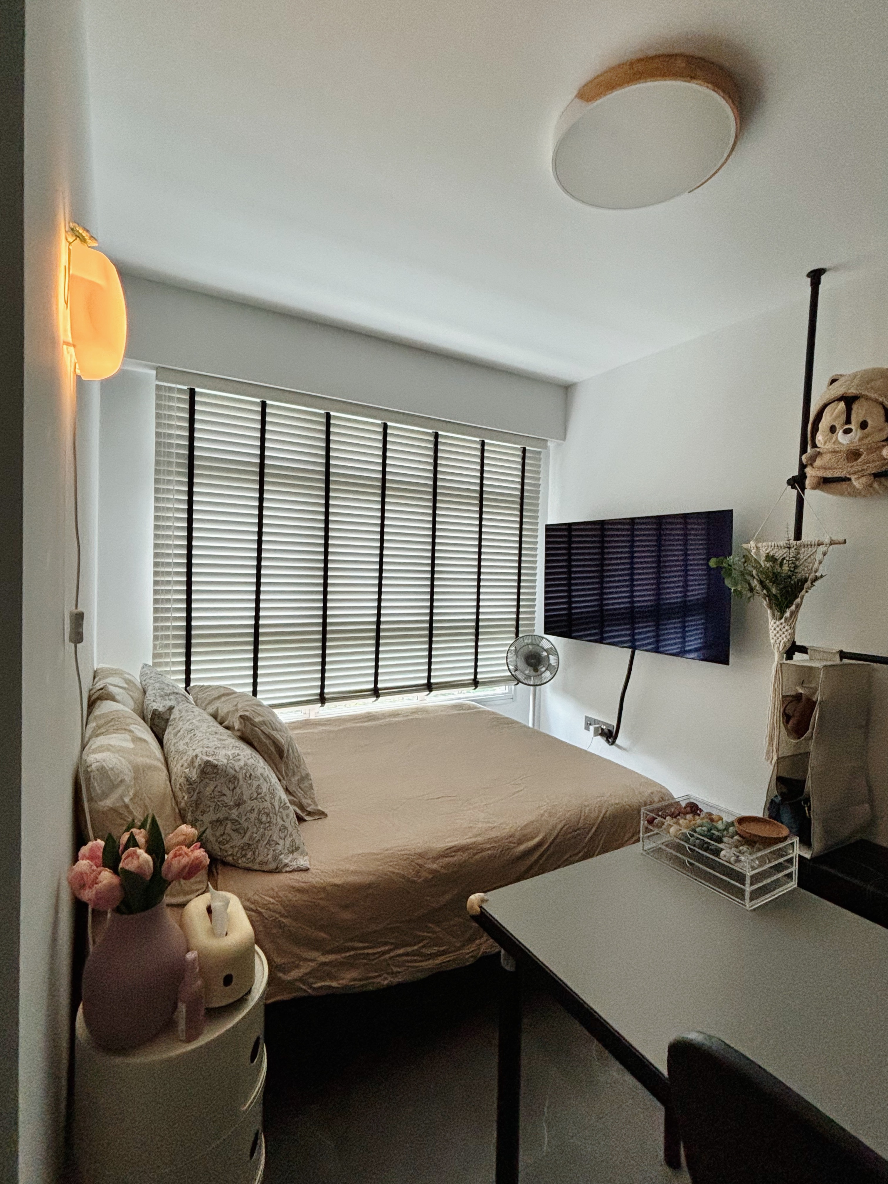 Simple Space, Big Comfort: Step Into Our Guest Room - Sunlit bedroom with beige bed, patterned pillows, and floral