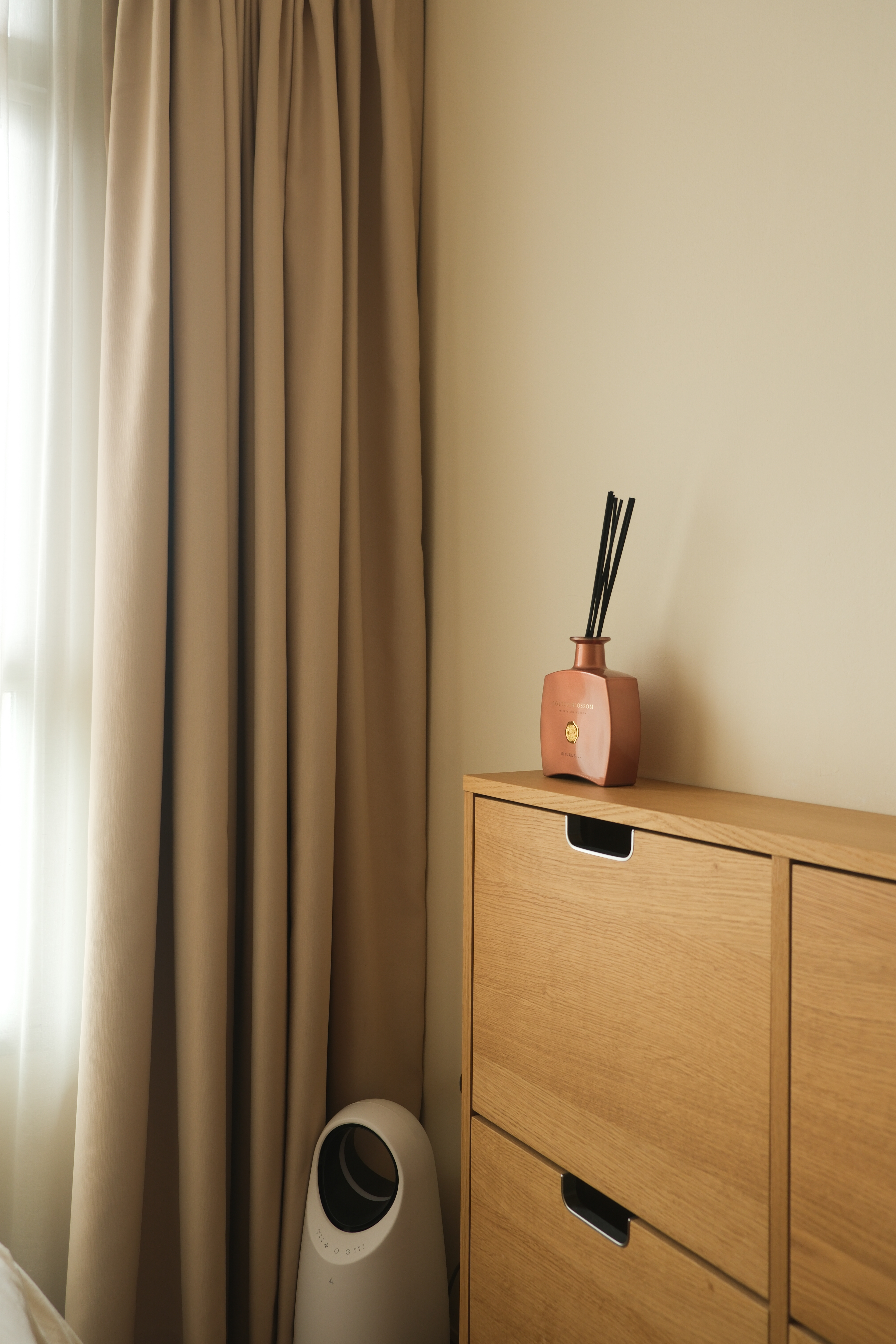 Minimalist Japandi Elegance. Warm tones and natural light.  - Beige curtains, soft lighting, modern decor, wooden dresser