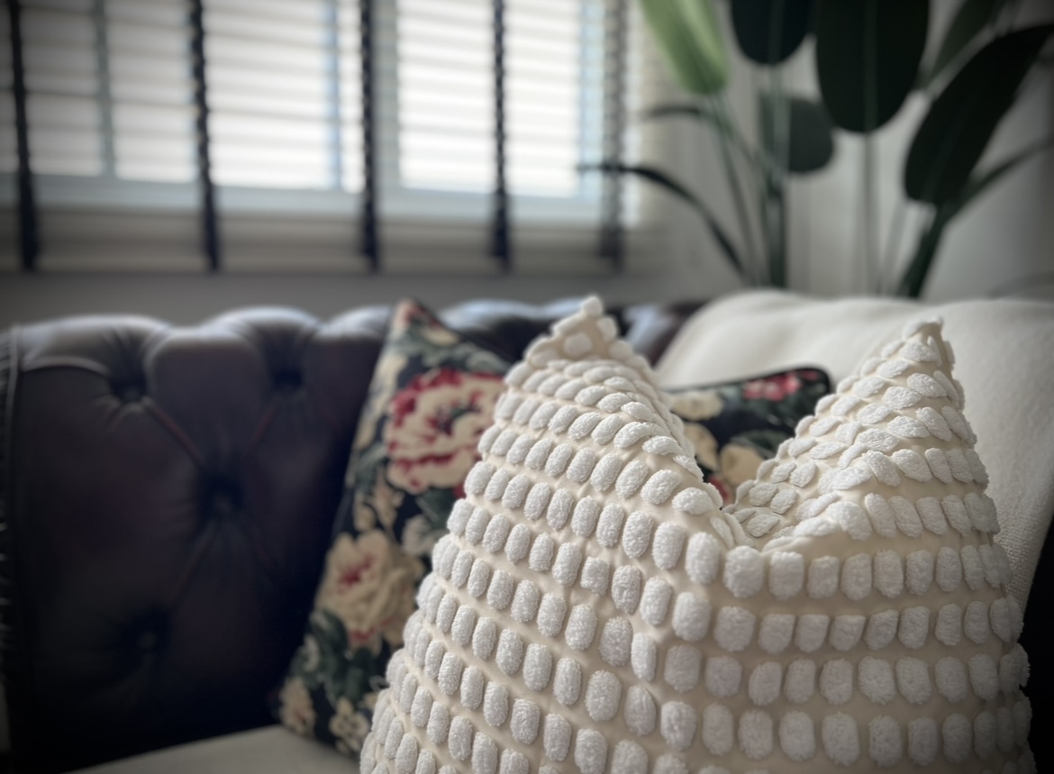 The heart of the home, where conversations flow and memories made. - Cream-colored, textured, decorative pillows on a dark