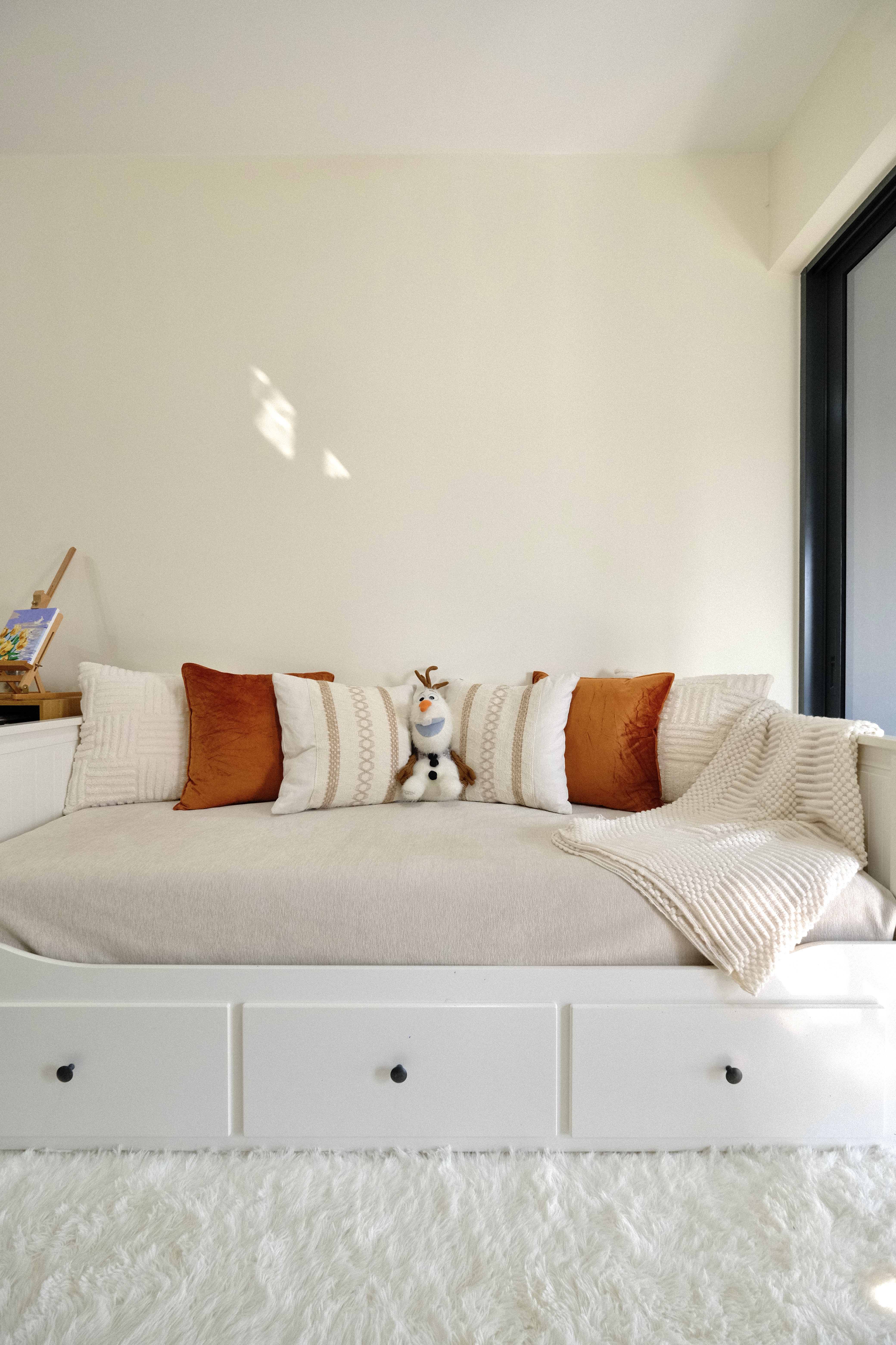 Inviting you to step into our favorite haven in the house! ✨ - White cozy sofa, plush white rug, wooden side table, colorful