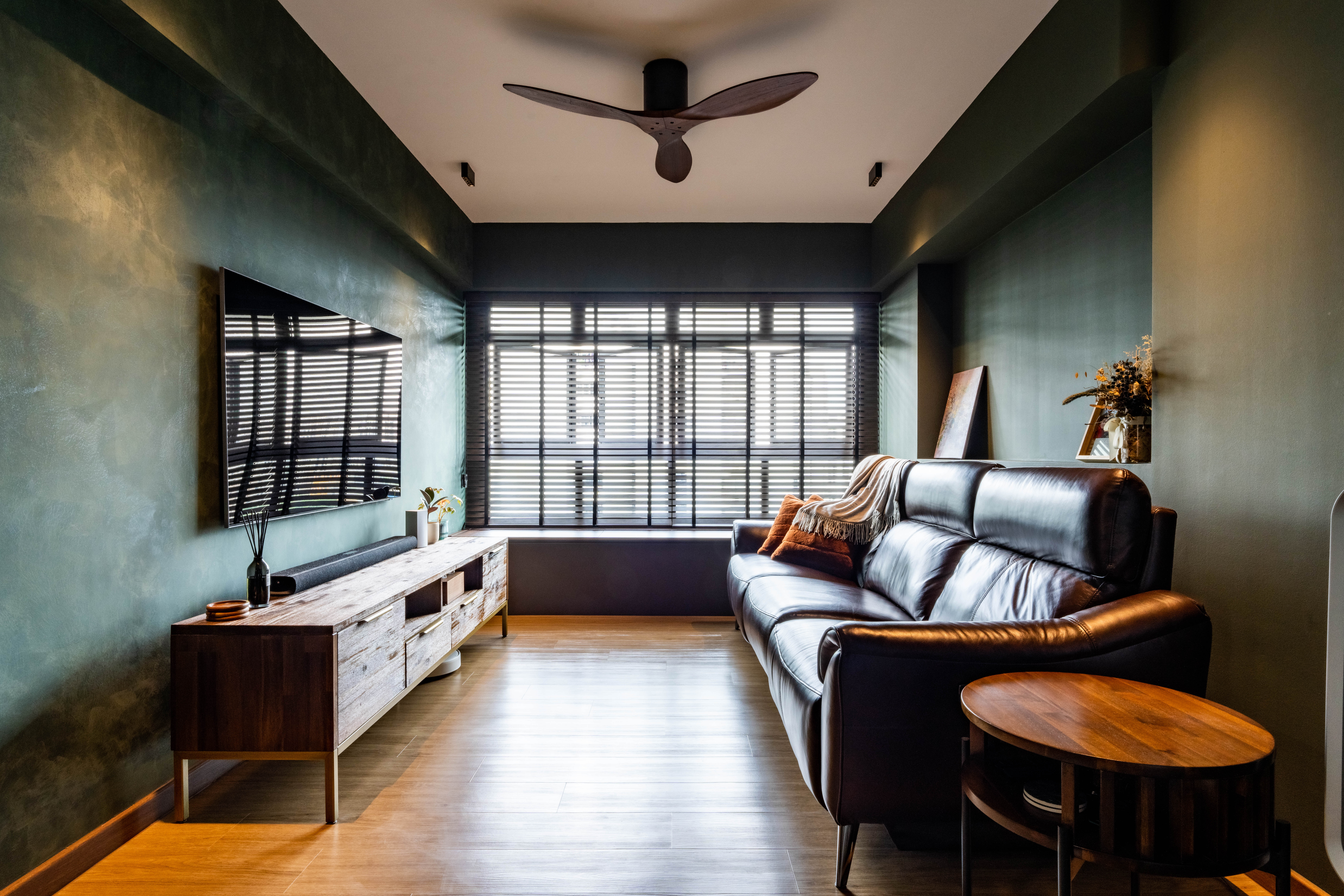 The living - Modern living room with sleek design, dark green textured walls, large window with blinds, wooden floor