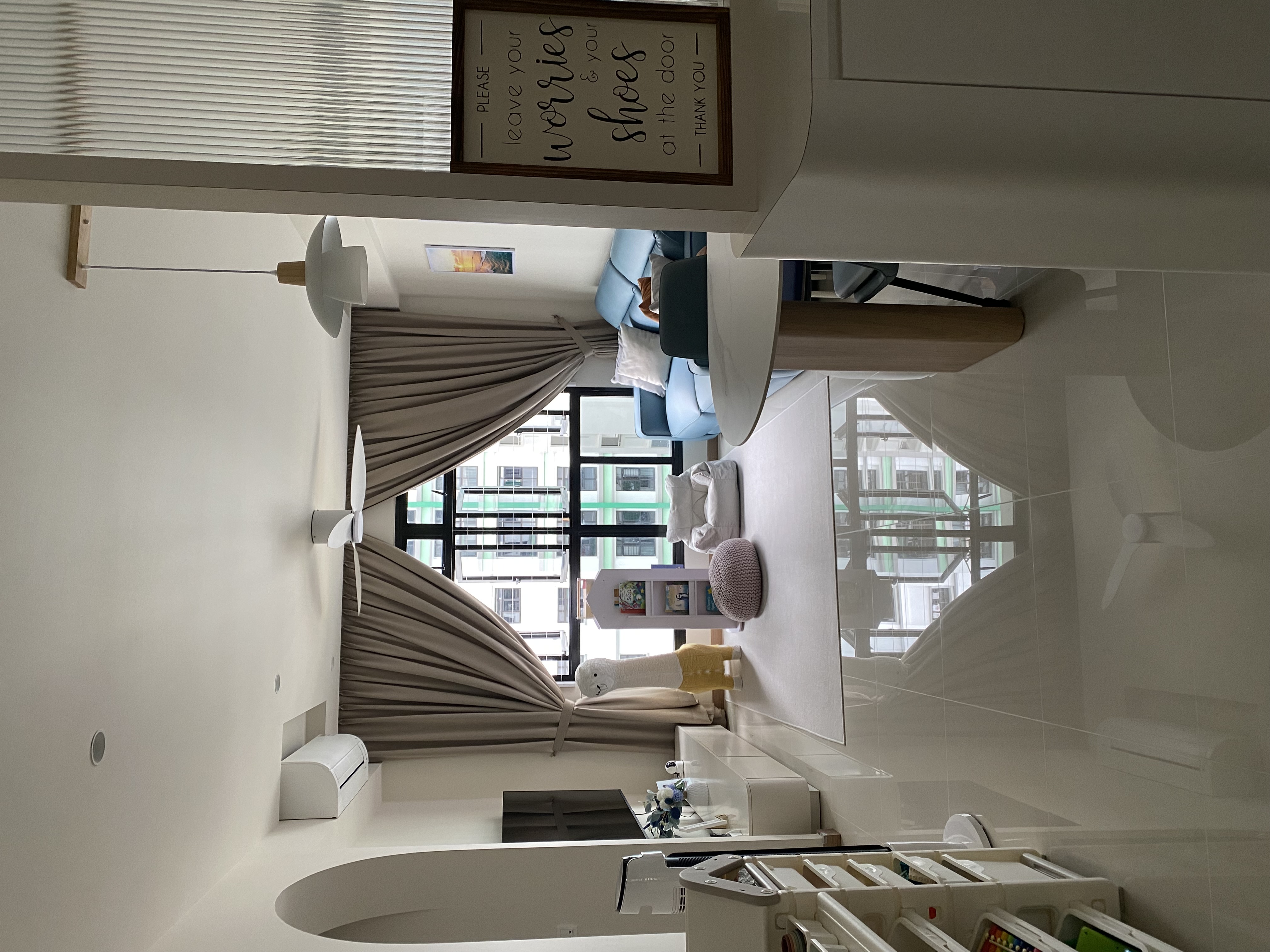 A cosy coastal kid-friendly haven  - Modern minimalist living room, cozy seating area, large windows, soft beige curtains