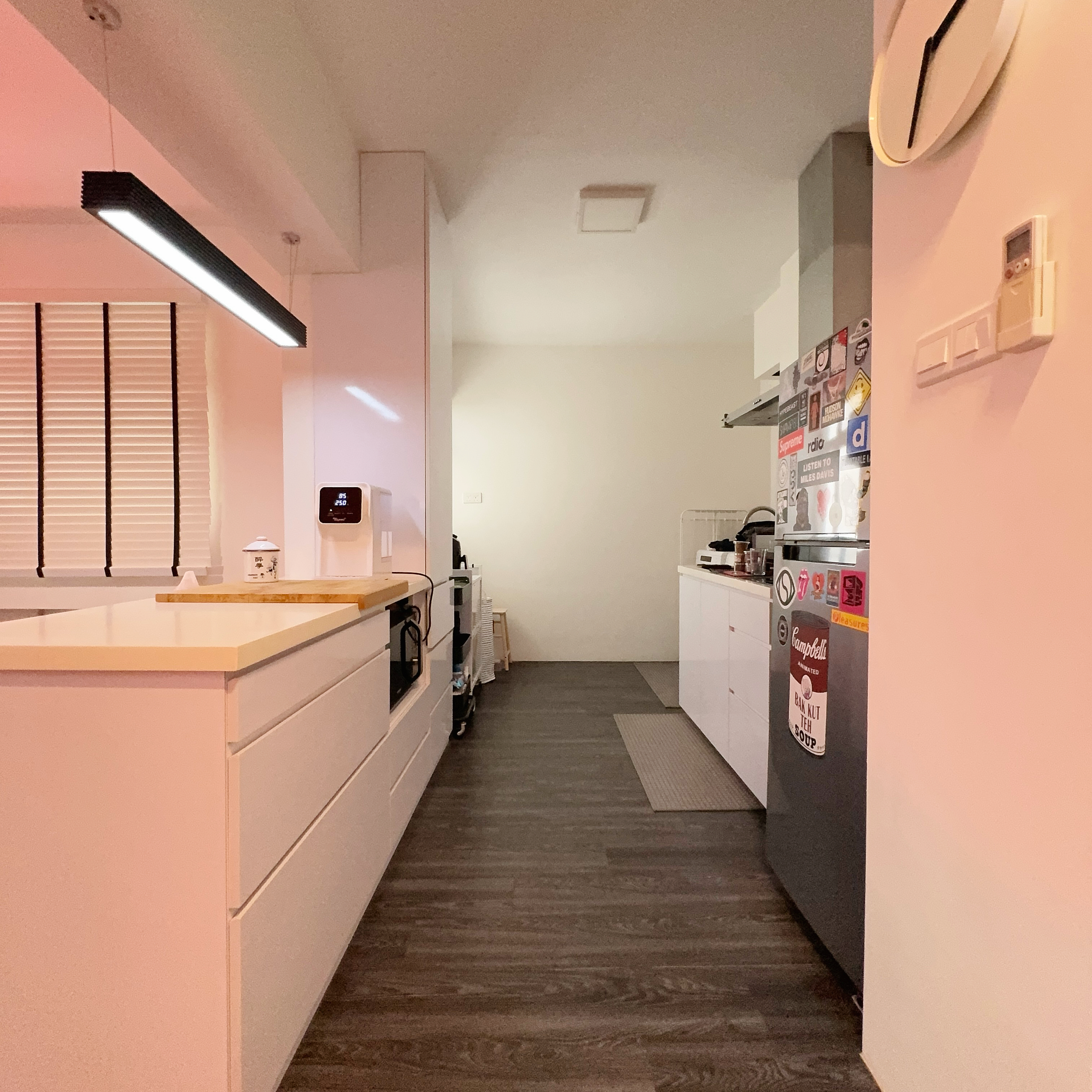 Simplicity in Style: A Tour of Our Minimalist Kitchen with A Twist - Modern kitchen with sleek white cabinetry, pendant light