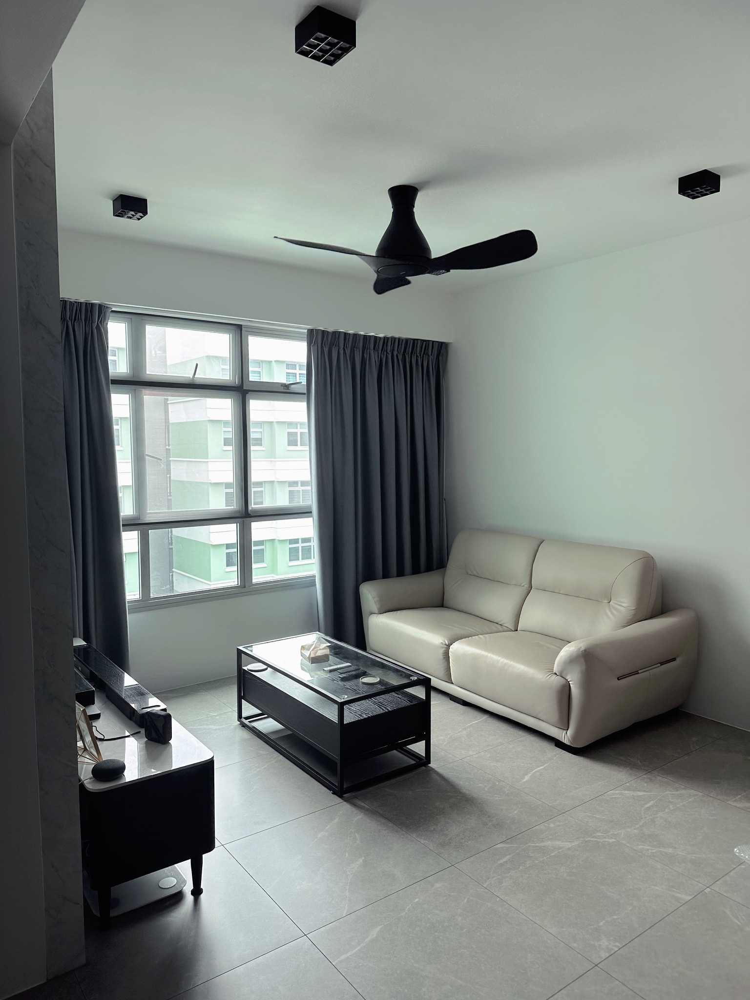 Cosy Living Room: Before & After! - Modern minimalist living room, sleek ceiling fan, large window with green facade, gray