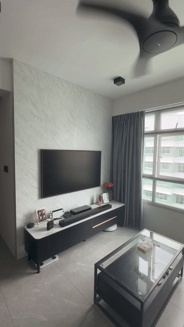 Cosy Living Room: Before & After! - Modern living room with sleek black entertainment unit, large flat-screen TV, minimalist