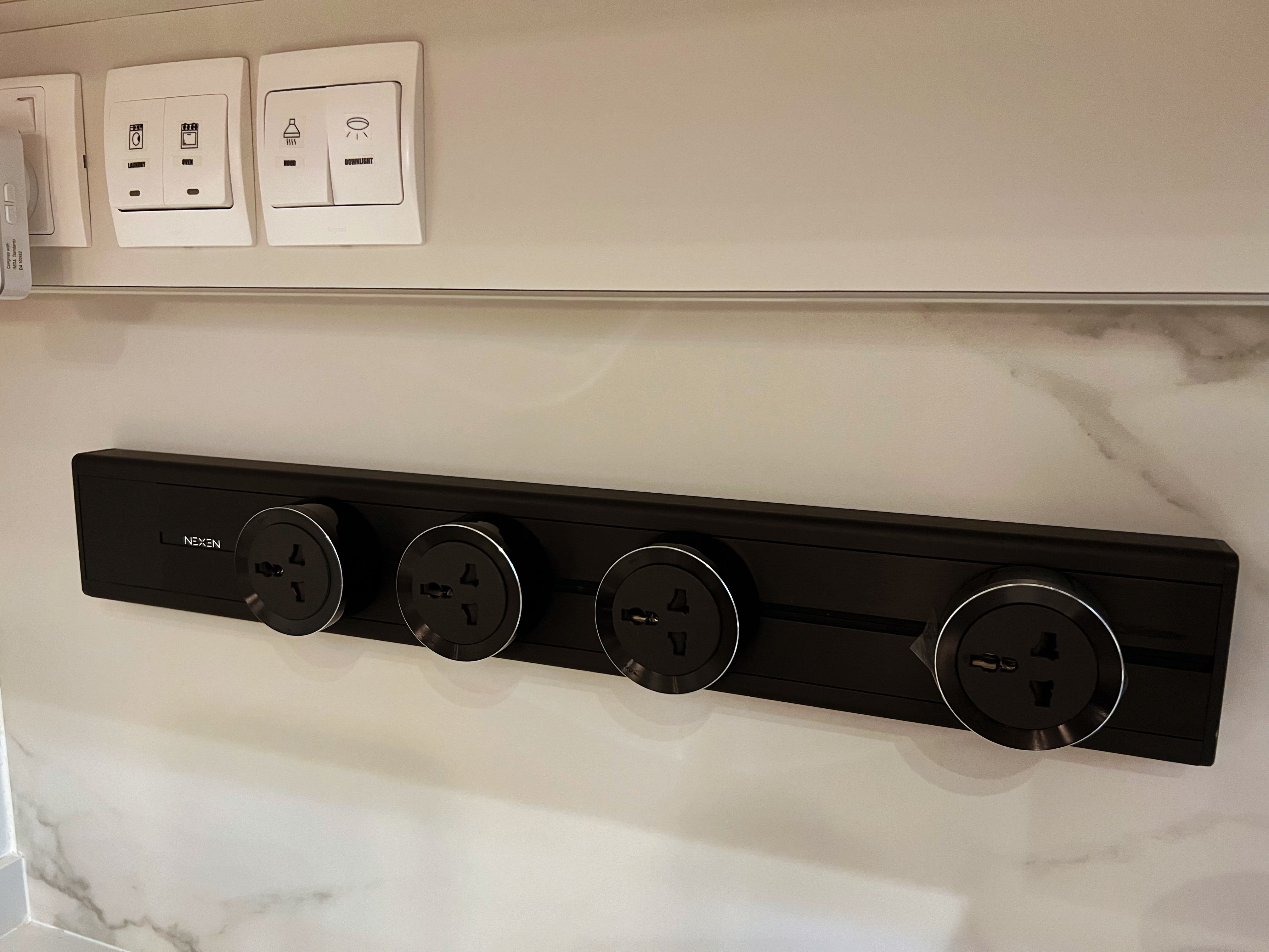 An all white kitchen separated  into wet and dry areas - Smart light control panel, sleek black panel, modern design