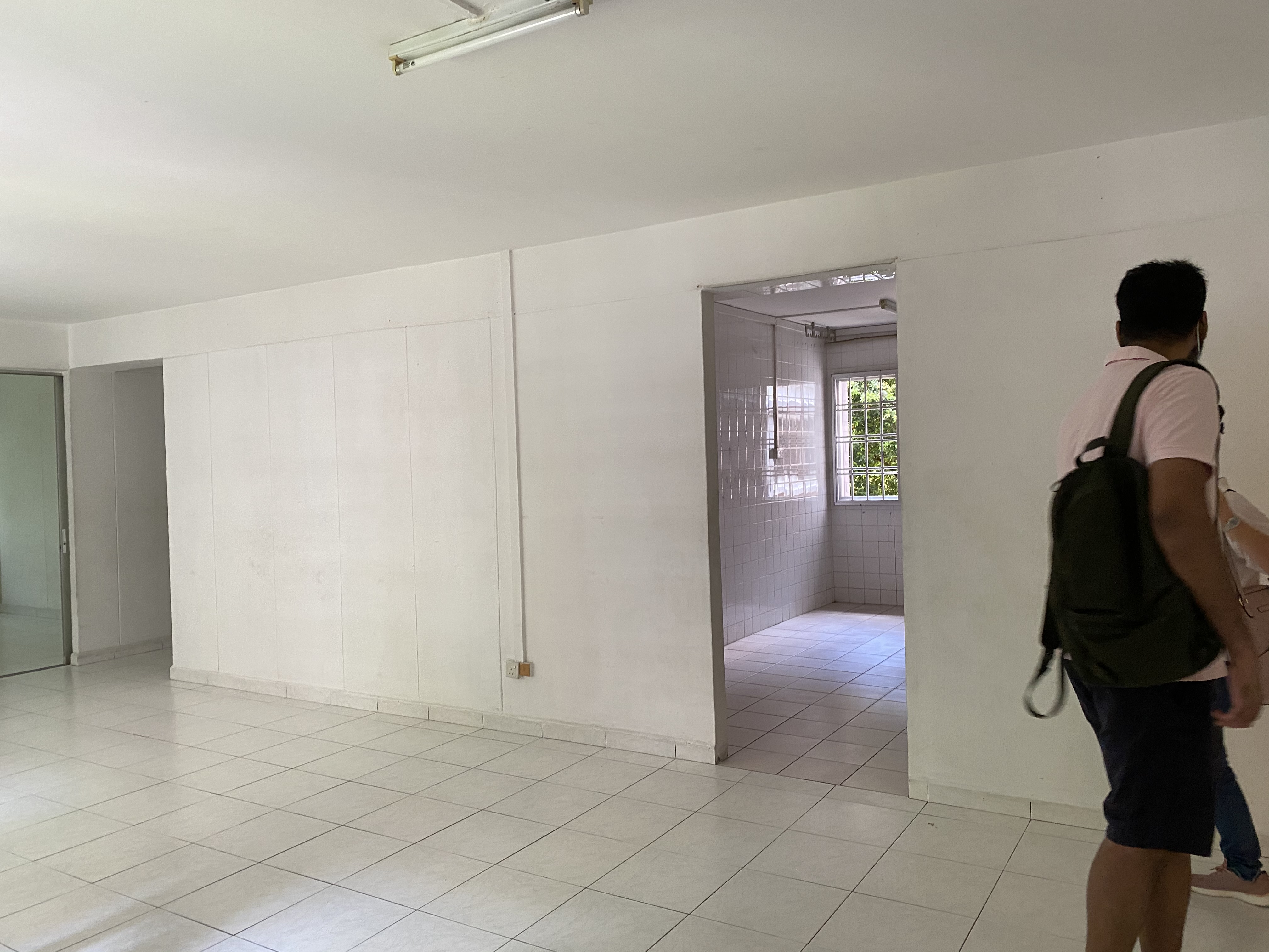 A Minimalist Kitchen Hidden in Our Maximalist Home - White tiled walls, open doorway, bright natural light, tiled floor