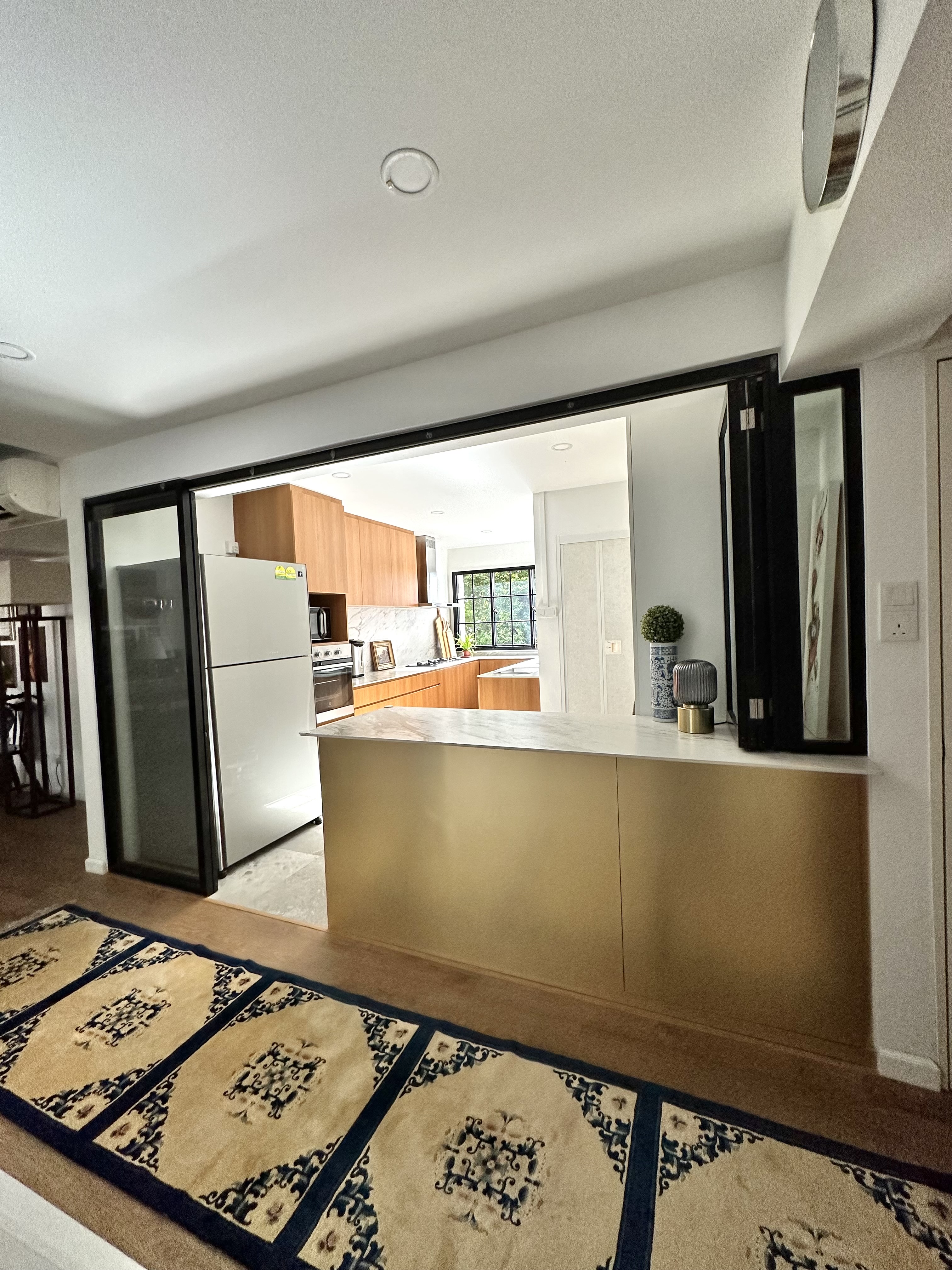 A Minimalist Kitchen Hidden in Our Maximalist Home - Modern kitchen with sleek design, stainless steel refrigerator, wooden