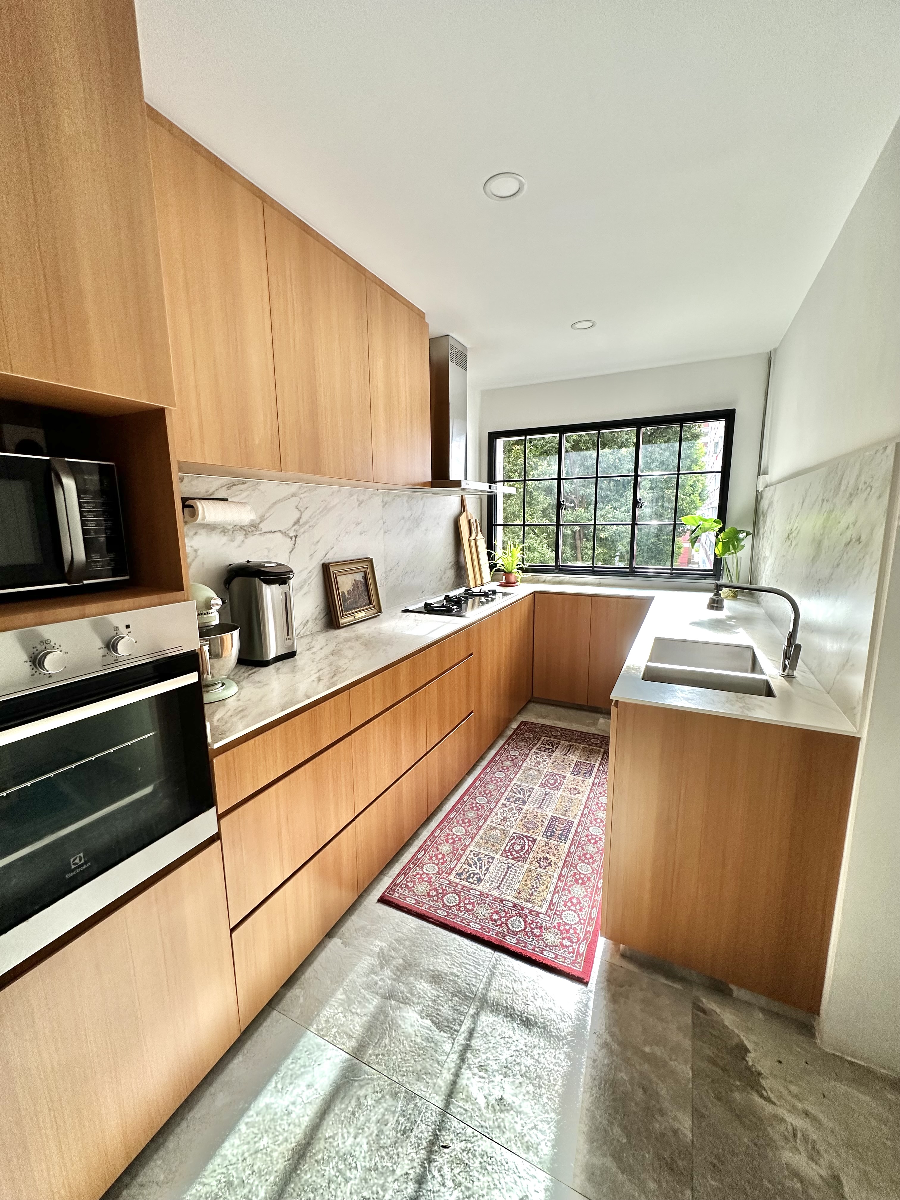 A Minimalist Kitchen Hidden in Our Maximalist Home - Wooden kitchen cabinets, marble backsplash, modern appliances, stainless