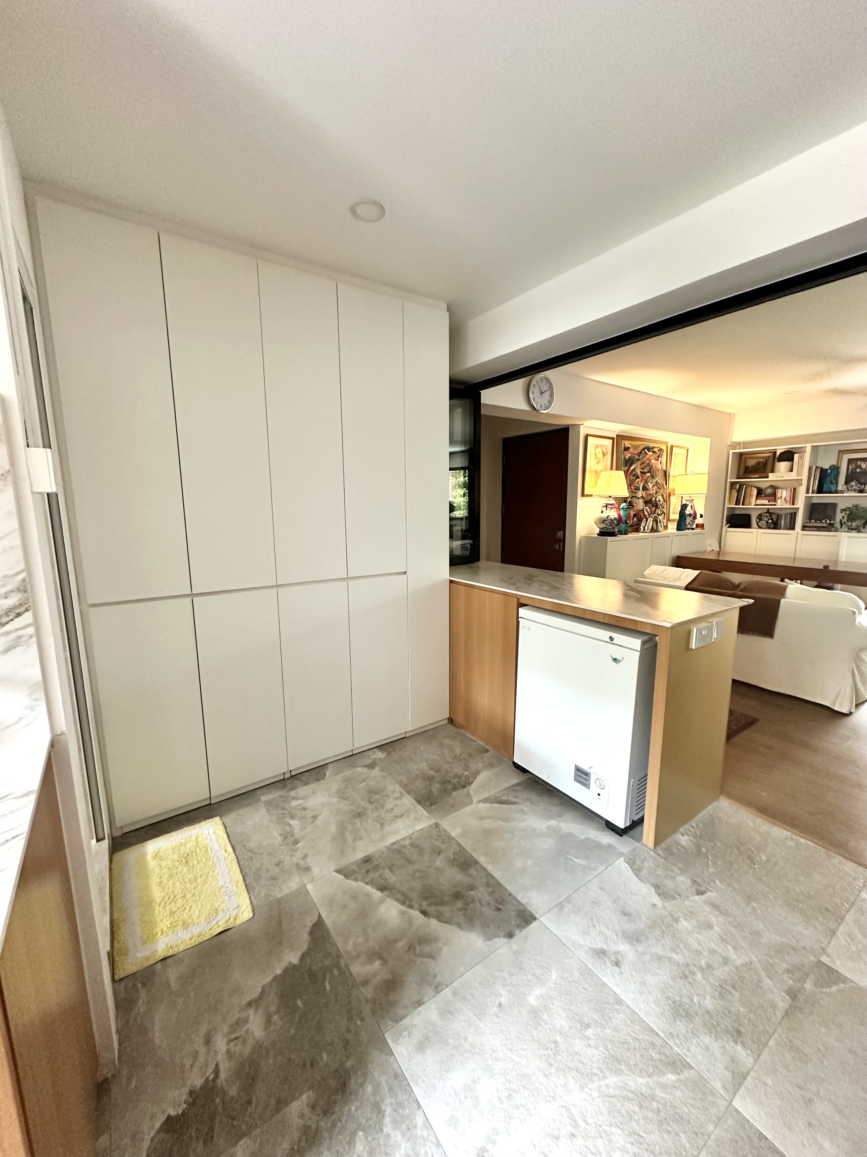 A Minimalist Kitchen Hidden in Our Maximalist Home - White kitchen cabinets, marble floor tiles, modern design, open doorway