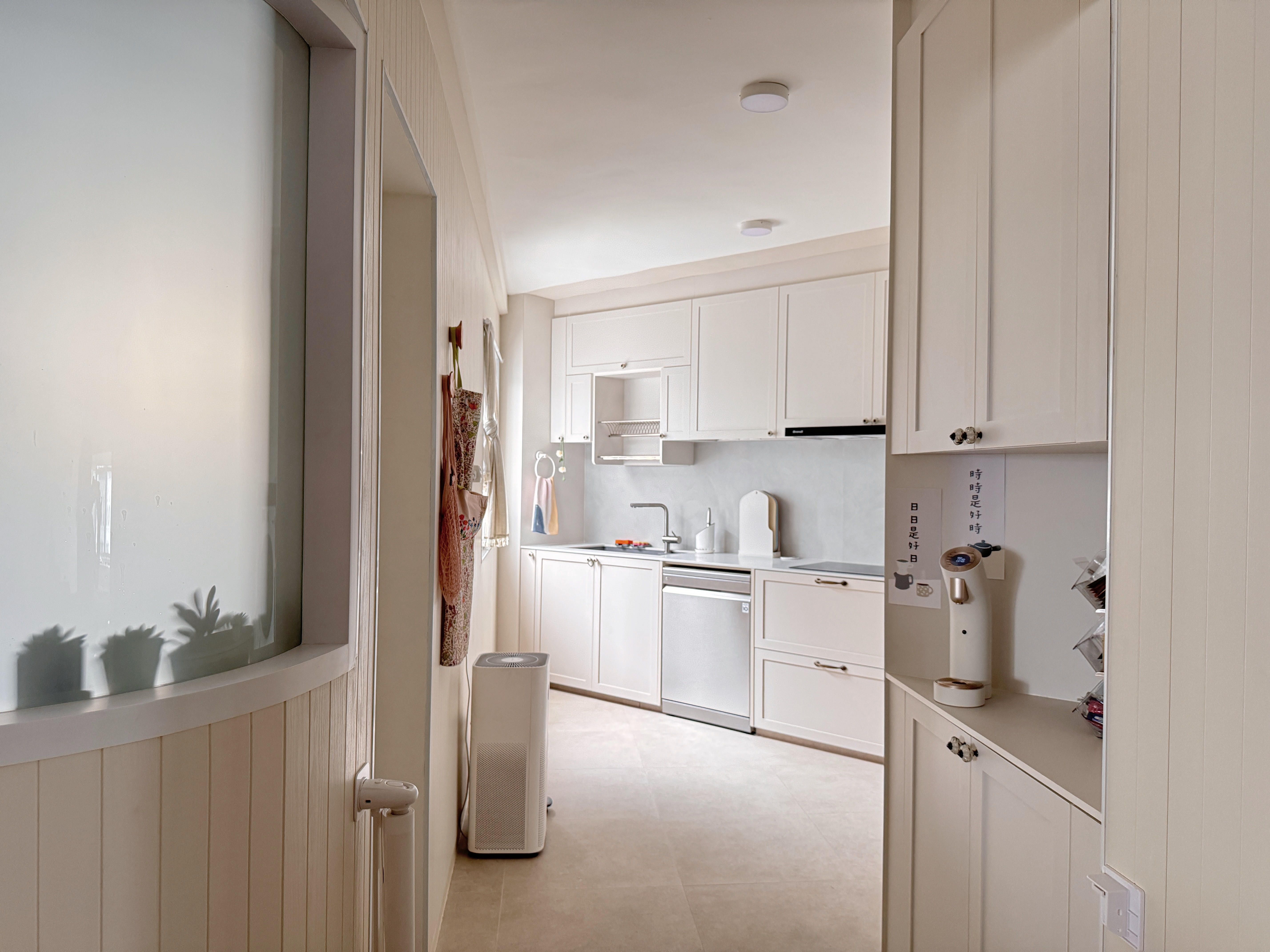 Small Kitchen, Big Ideas: Our Triangle Layout with Laundry Space - White kitchen with modern appliances, beige cabinets