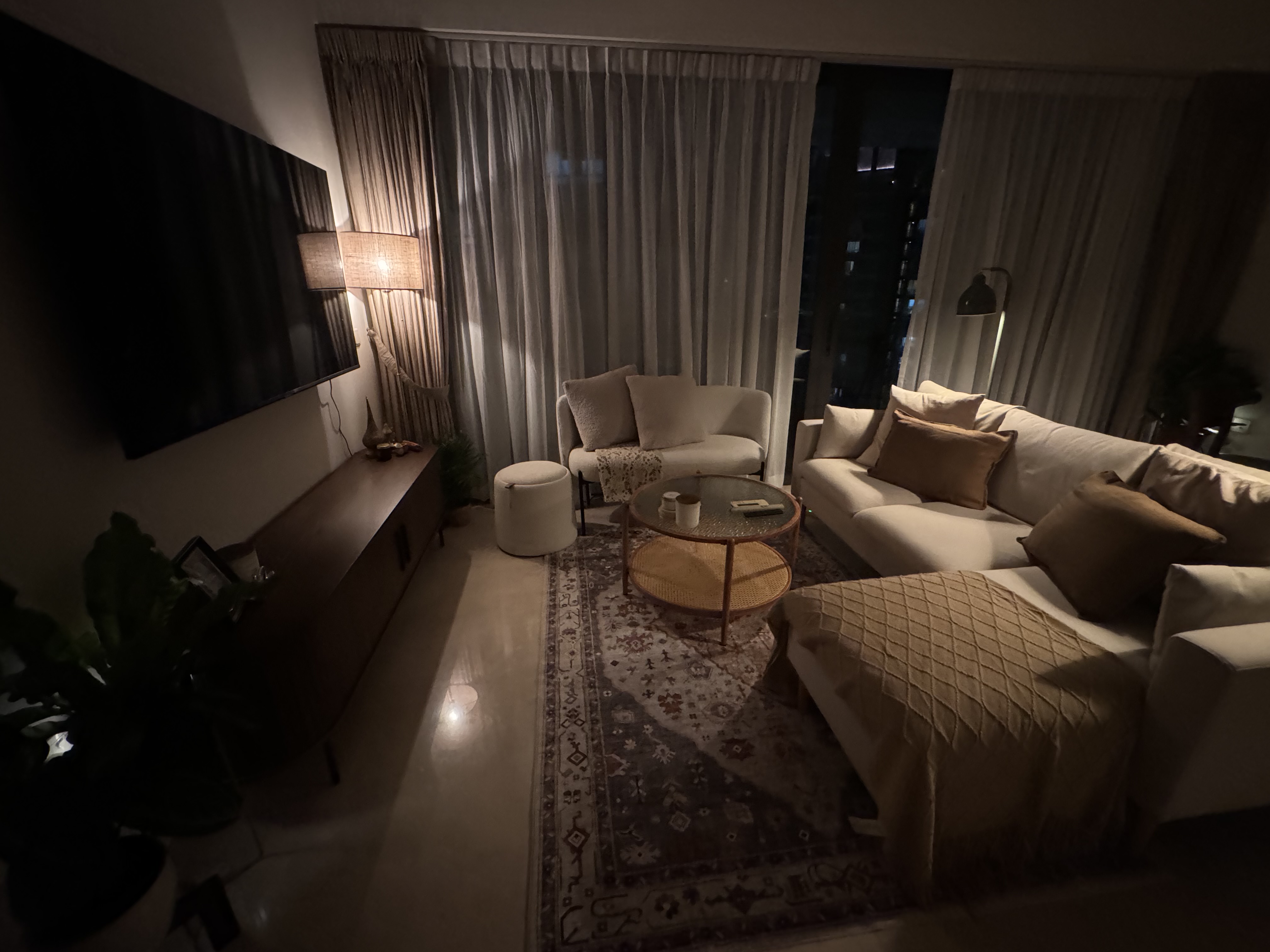 Mixed Bag  - dimly lit living room, cozy atmosphere, modern decor, beige sofa, brown cushions, round coffee table, floor
