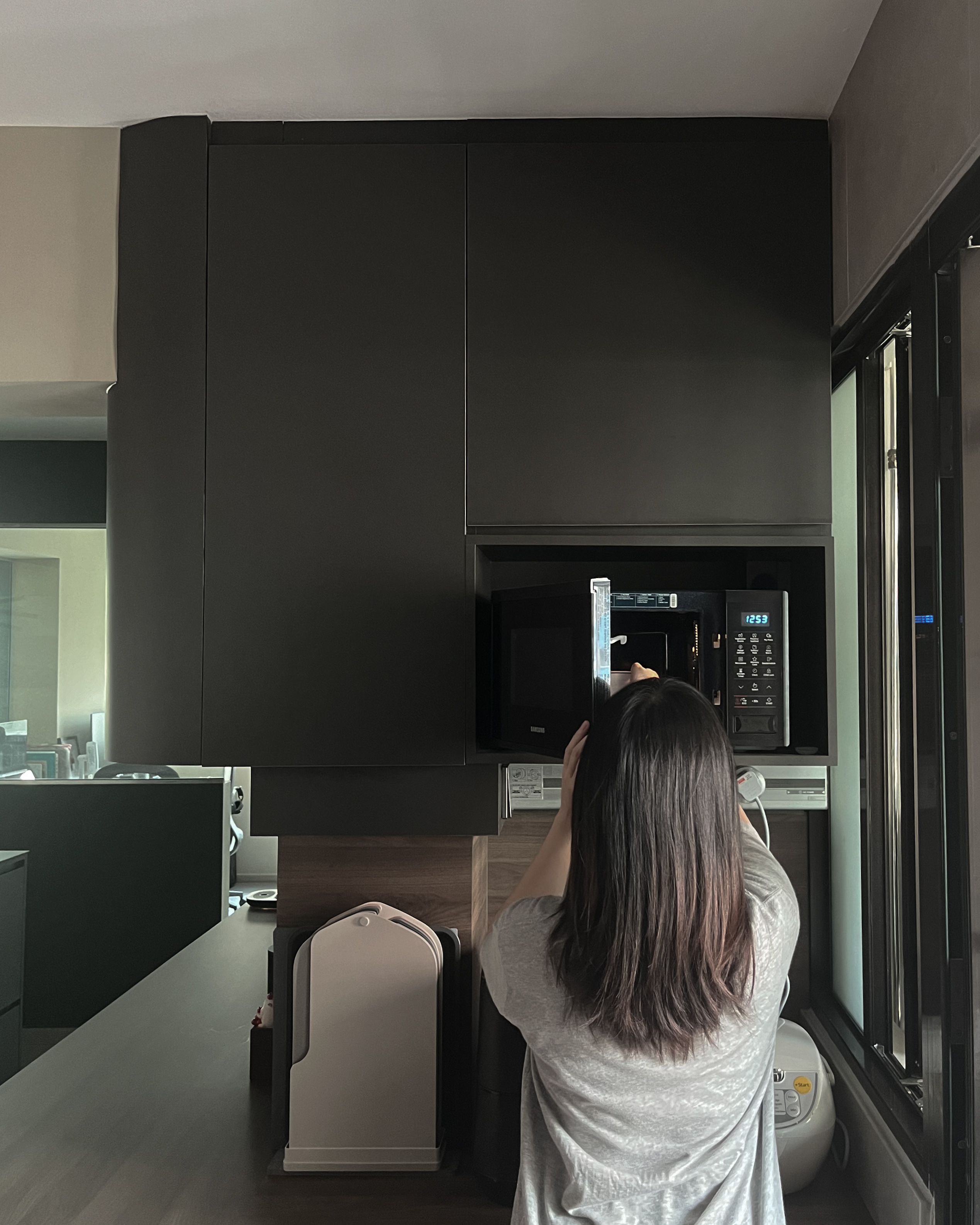 How Our Dark, Contemporary Kitchen Transforms From Day to Night - black cabinets, modern kitchen, woman cooking, microwave