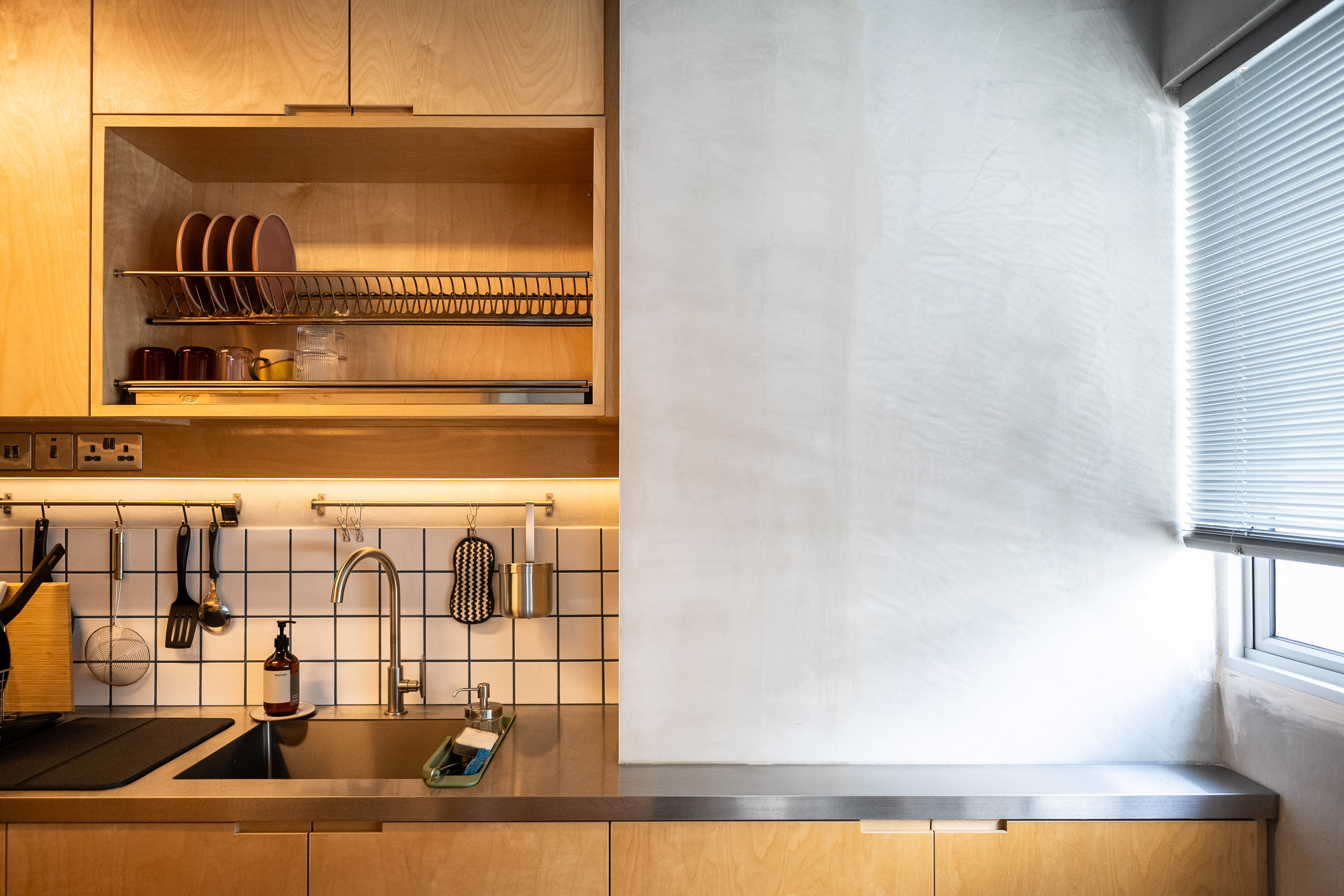 A Coffee Lover's Spacious & Charming Kitchen - Wooden kitchen cabinets, stainless steel sink, white tiled backsplash, black