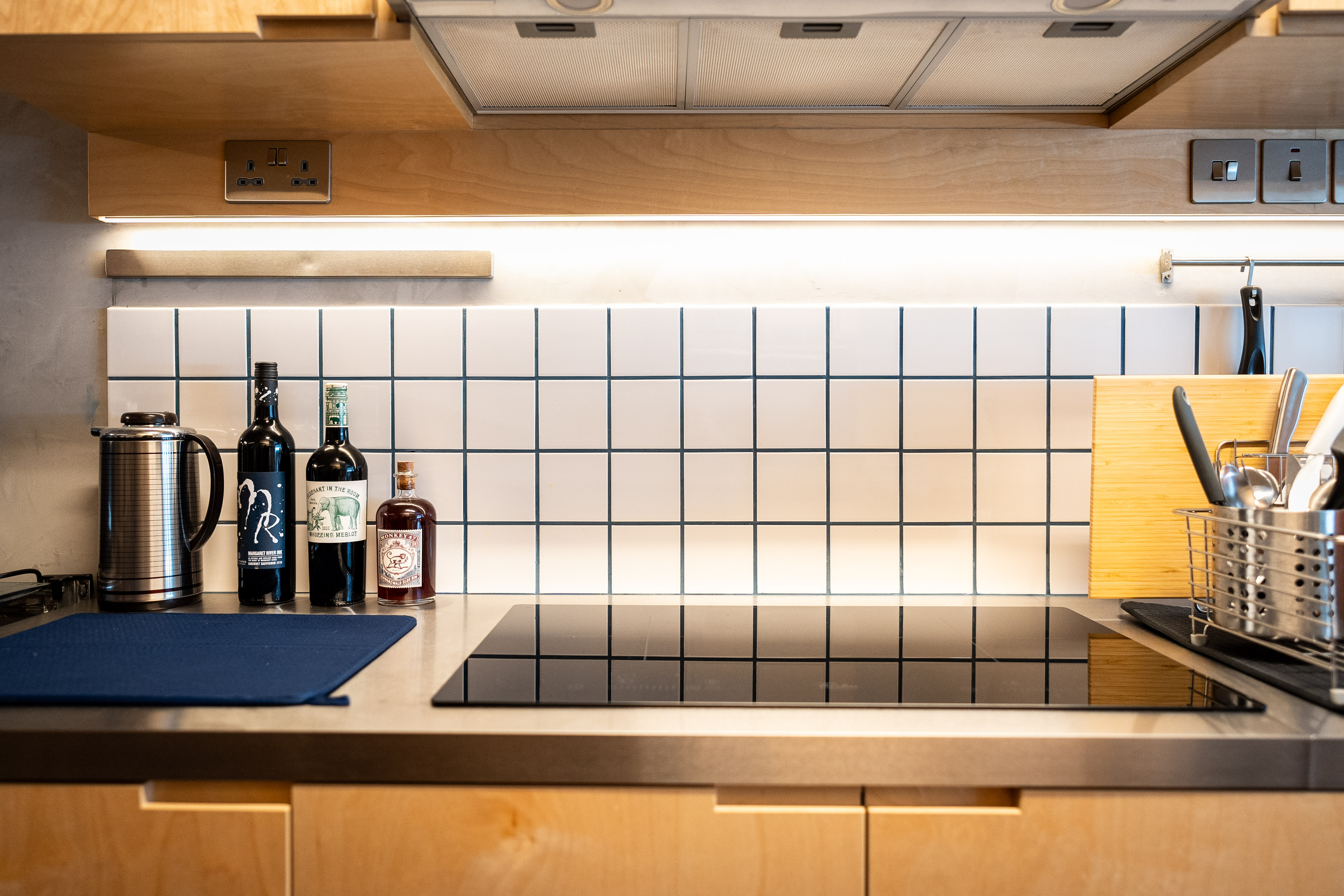 A Coffee Lover's Spacious & Charming Kitchen - Wooden kitchen cabinets, stainless steel appliances, tiled backsplash, modern