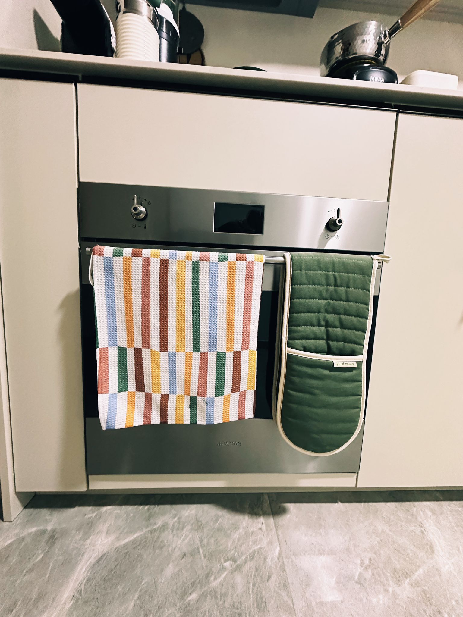 Maximizing Function in a Minimalist Kitchen: Our Small Cooking Haven  - striped oven mitts, kitchen towels, modern oven