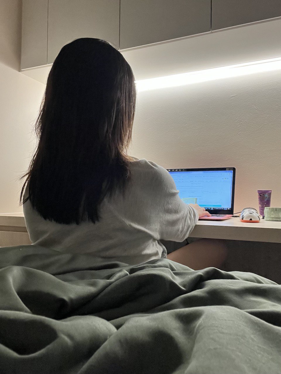 Coziest Corner of The House in This 3-Room BTO: Common Bedroom - woman sitting on bed, laptop screen visible, long dark hair