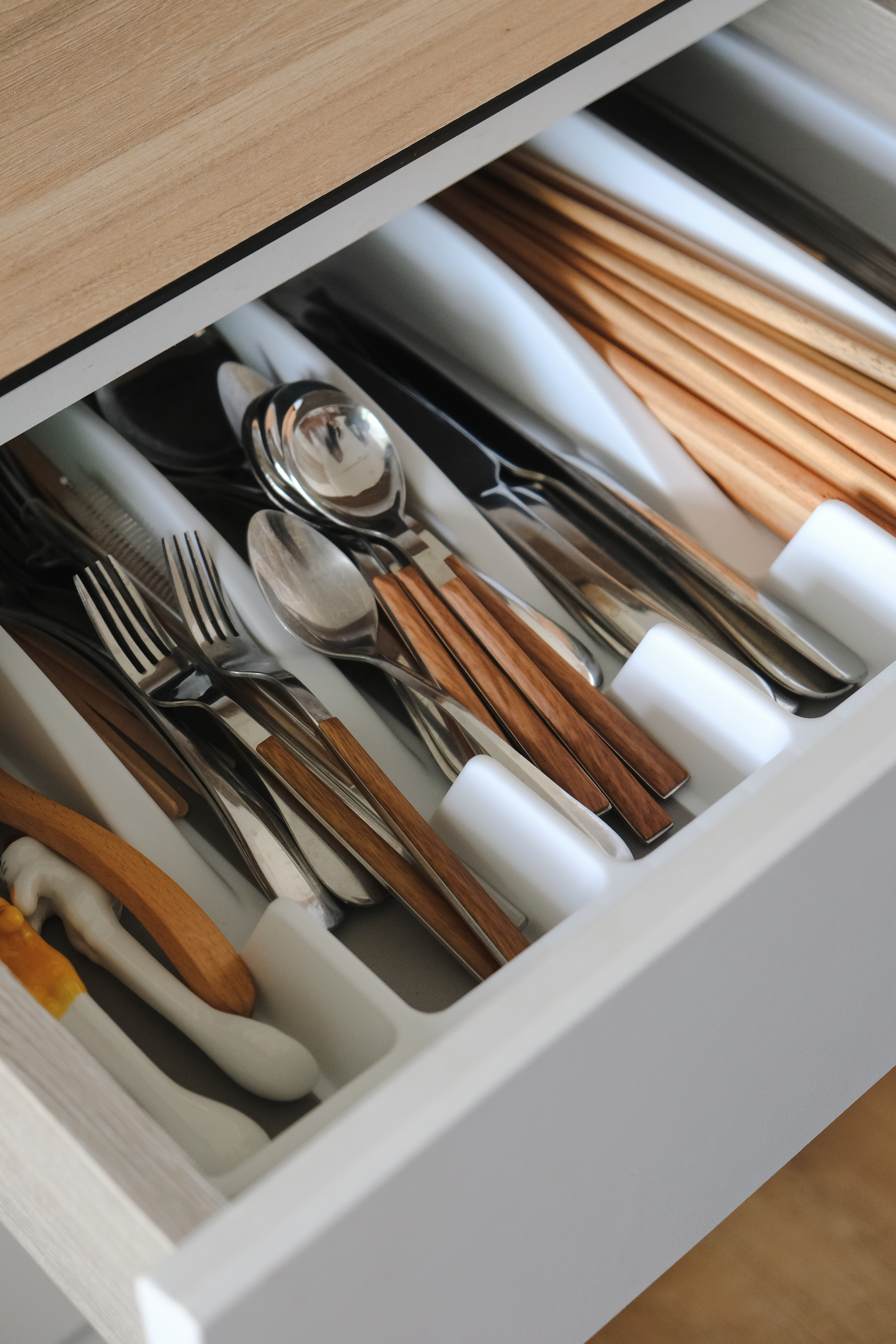 Clean and Functional: A Kitchen Designed with Smart Storage Solutions - Wooden drawer, neatly organized, stainless steel