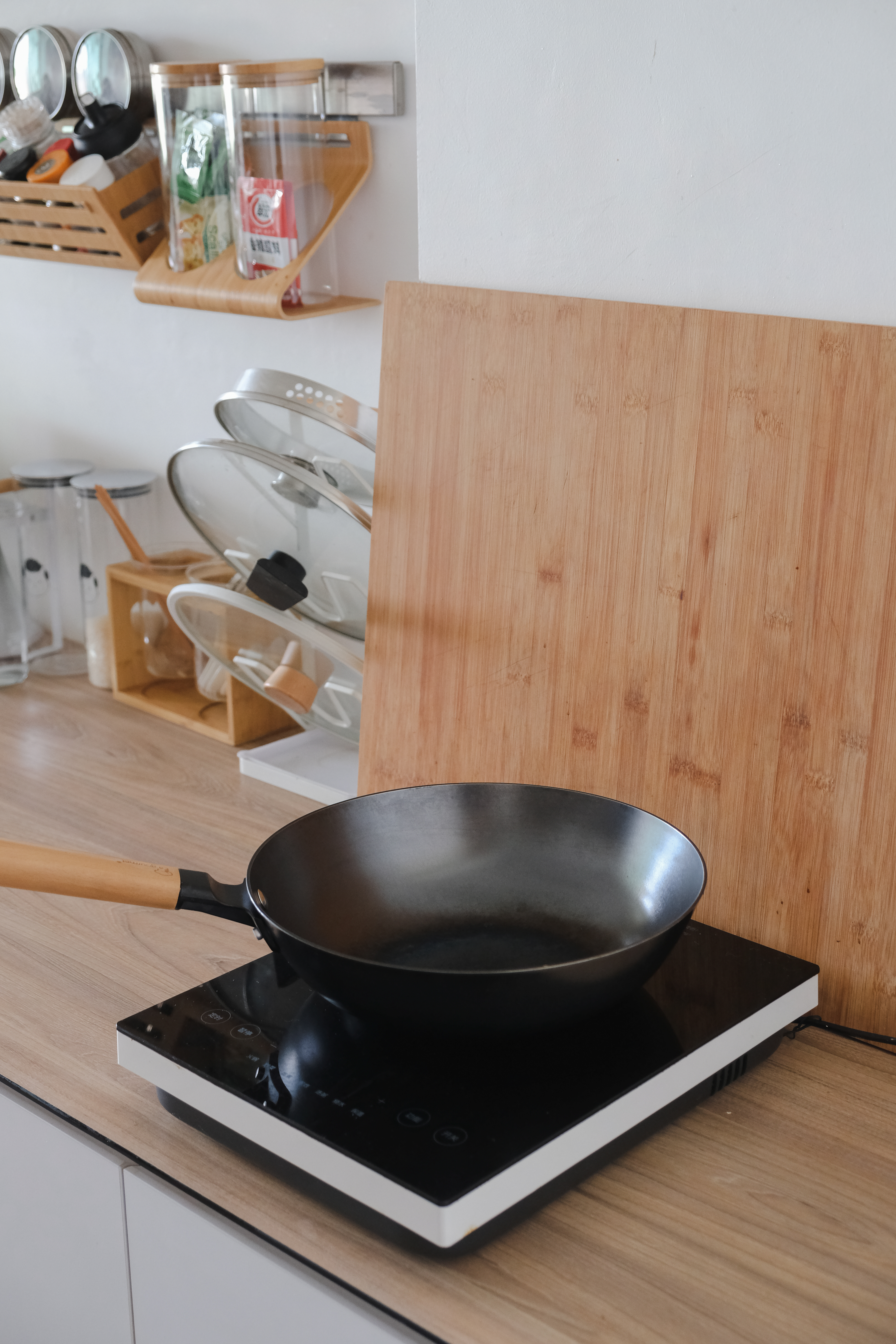 Clean and Functional: A Kitchen Designed with Smart Storage Solutions - Wooden kitchen countertop, black induction cooktop