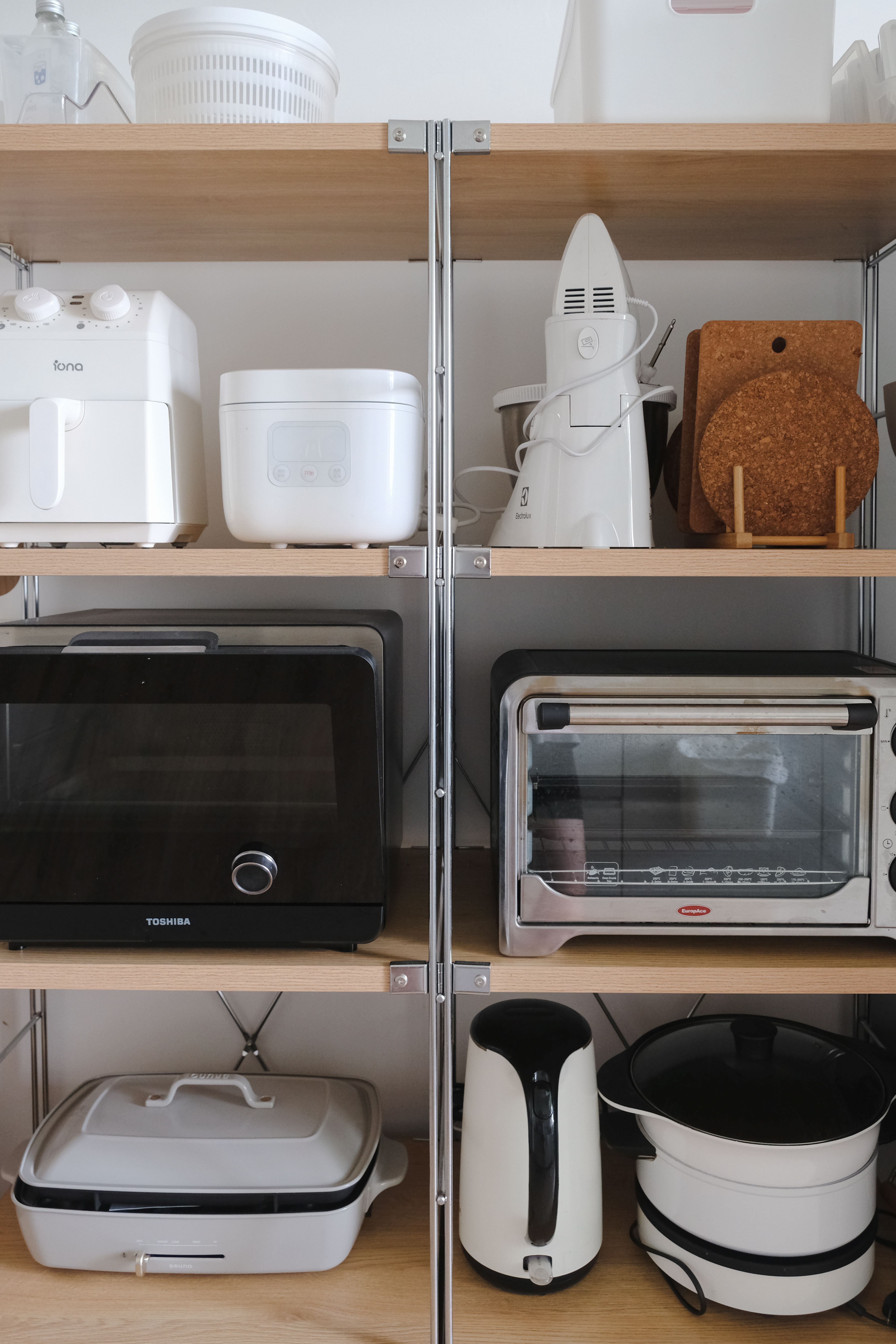 Clean and Functional: A Kitchen Designed with Smart Storage Solutions - White kitchen appliances on wooden shelves, including