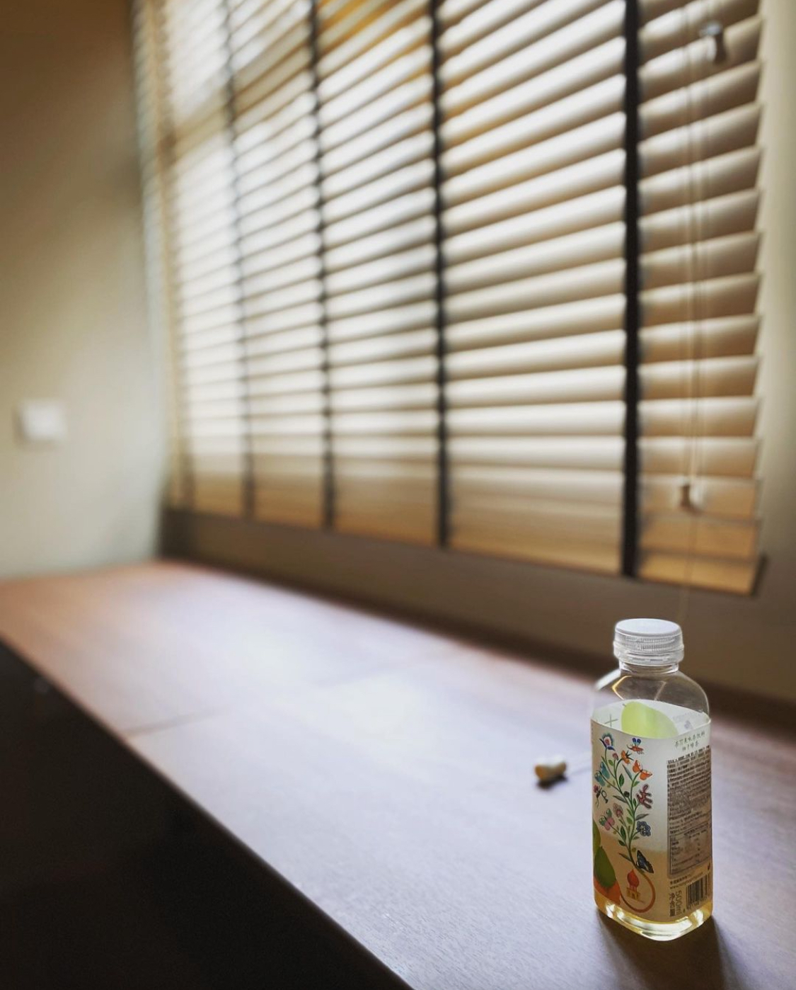 Here are some great ideas for renovating a small bedroom - Sunlit window blinds casting soft shadows, wooden table with a