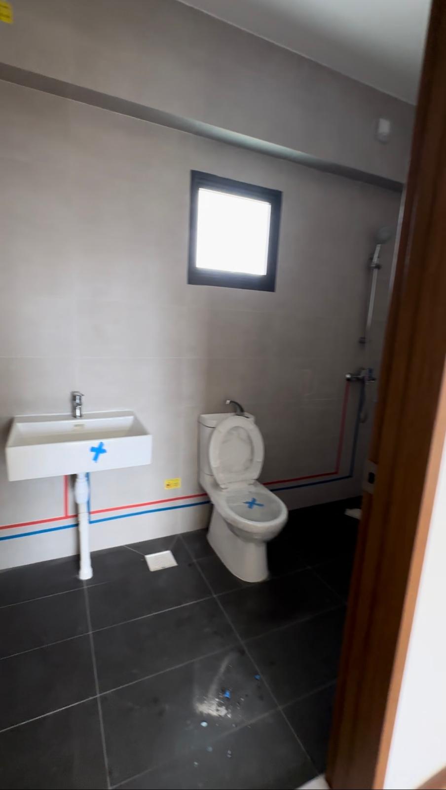 Before & After: Japandi Luxe Master bed & bath - Small bathroom with white sink and toilet, tiled floor with blue stains