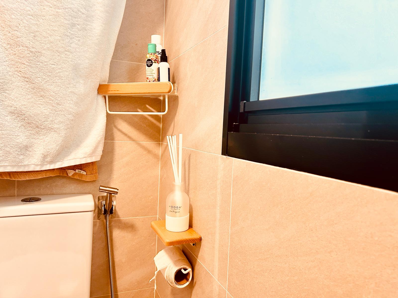 Airy and Inviting: A $26K Bohemian Mediterranean 4-RM BTO - Shower area with white towel, wooden shelf holding toiletries