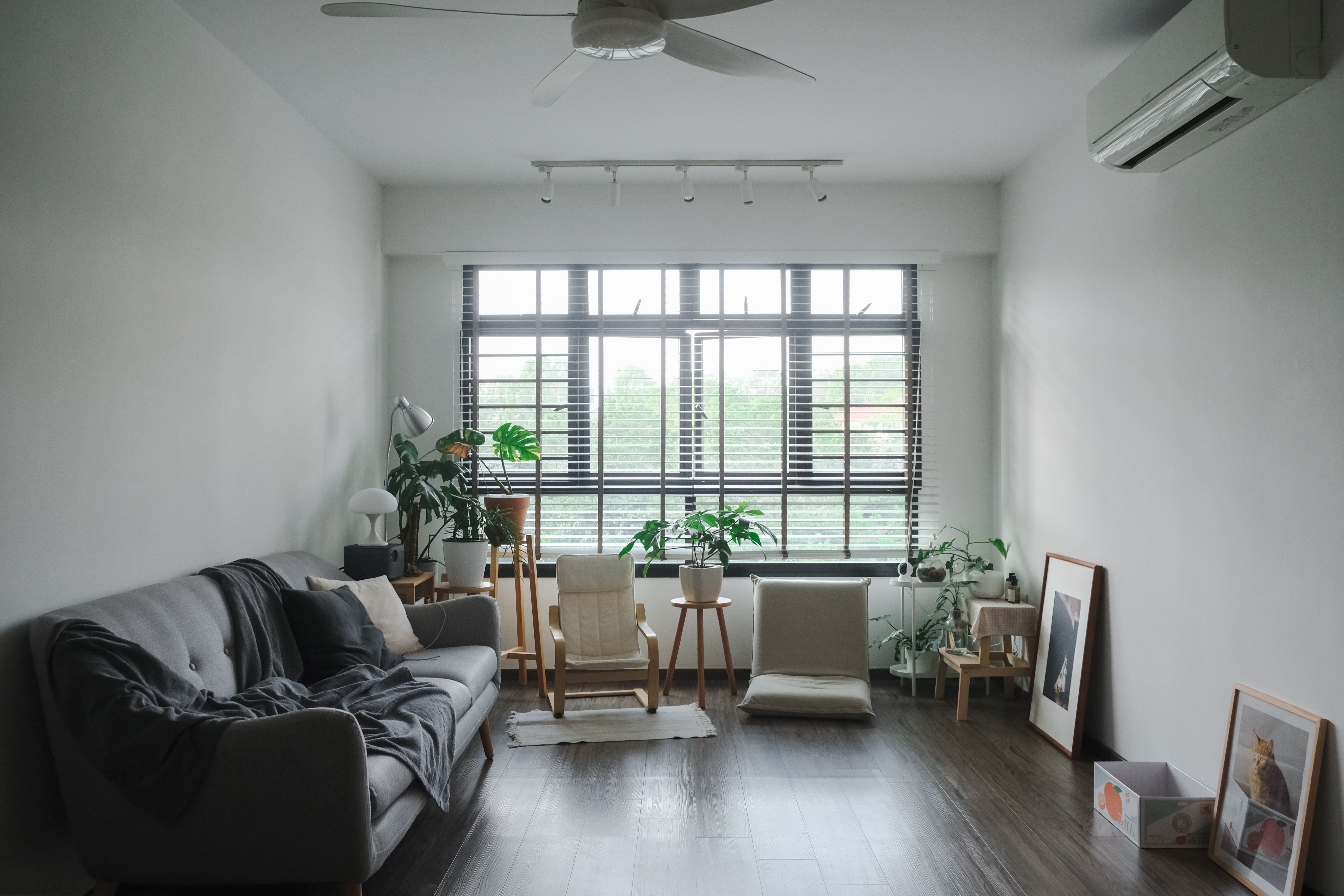 Japandi HDB Home with Unblocked Views: Renovated for Just $15K! - Modern living room with gray sofa, wooden chairs, and floor