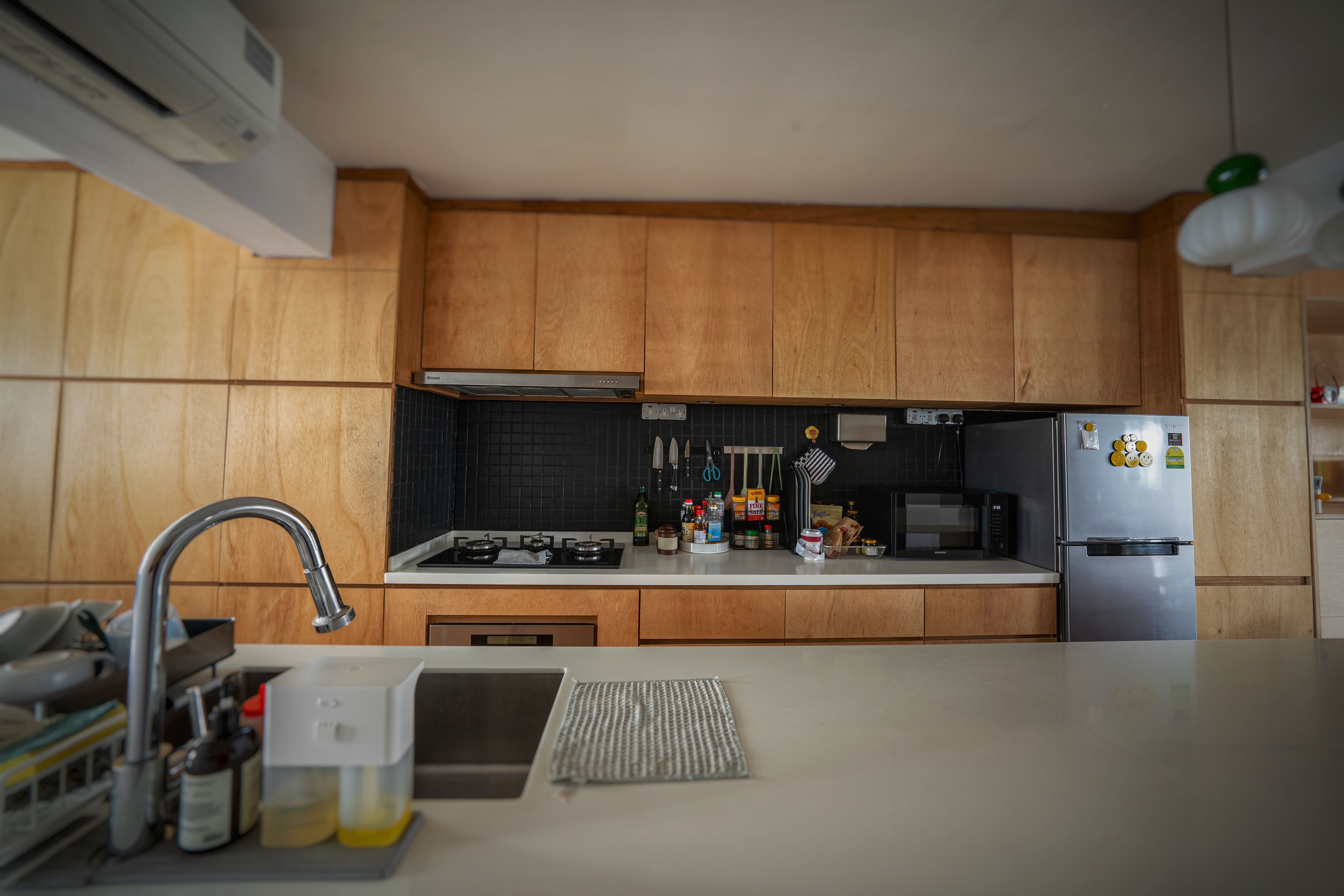 Our open kitchen concept - The plywood pantry. - Wooden cabinets, stainless steel sink, black tiled backsplash, modern