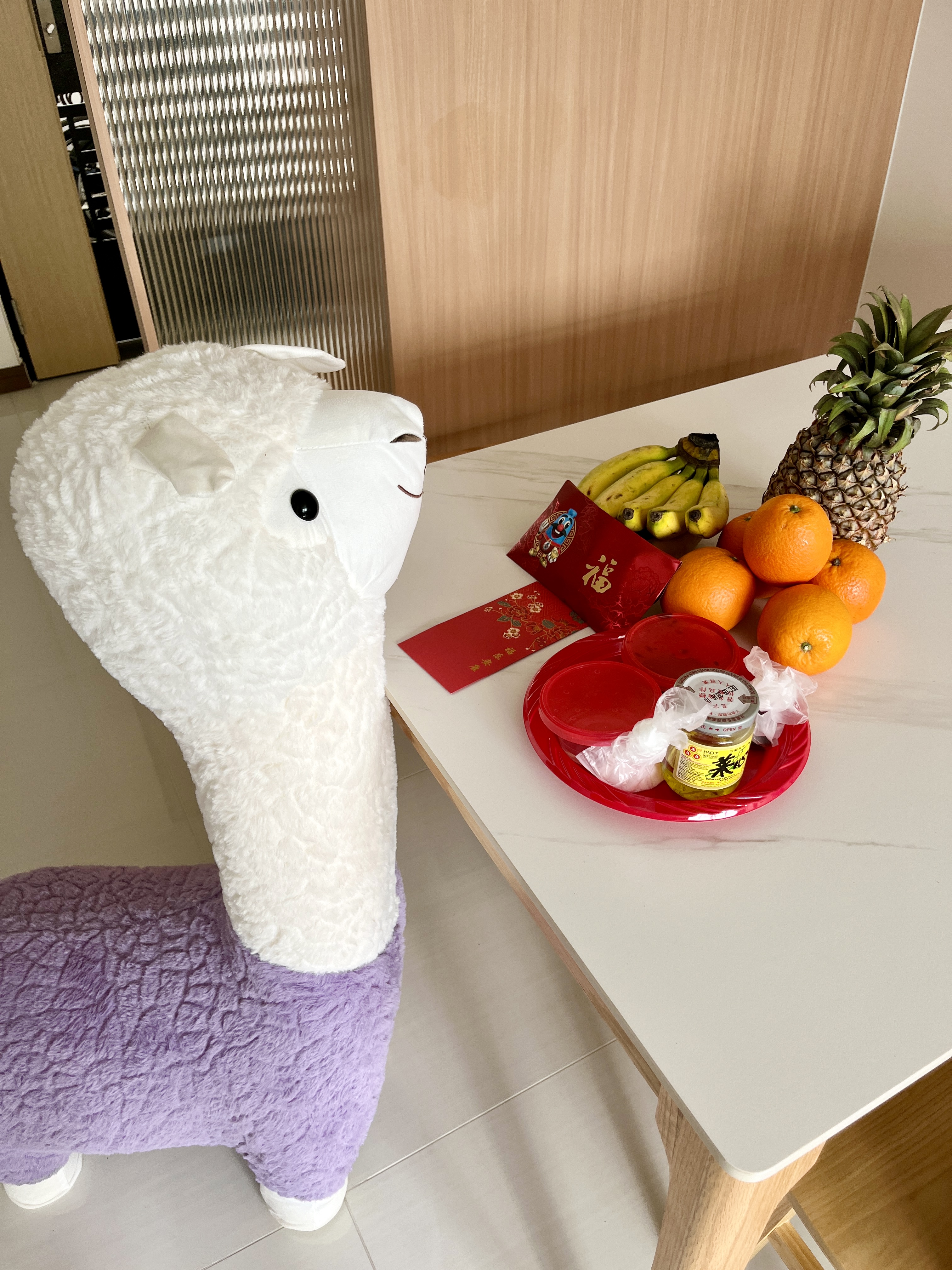 House Hunting: Our BTO Journey!  - Fur-covered llama, plush toy, white and purple, fluffy blanket, wooden table, red gift